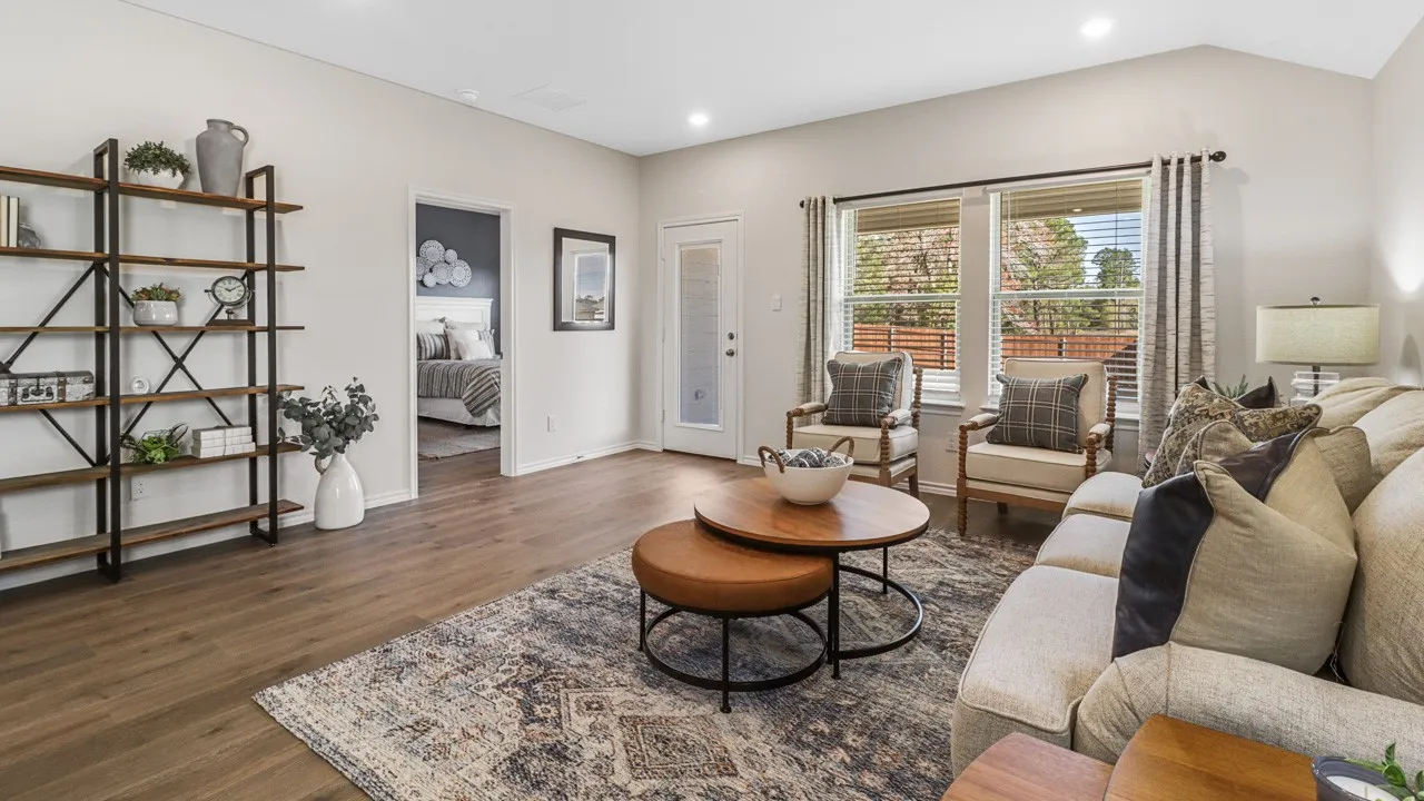 Spacious living area featuring wood-finish flooring, recessed lighting, and large windows with blinds