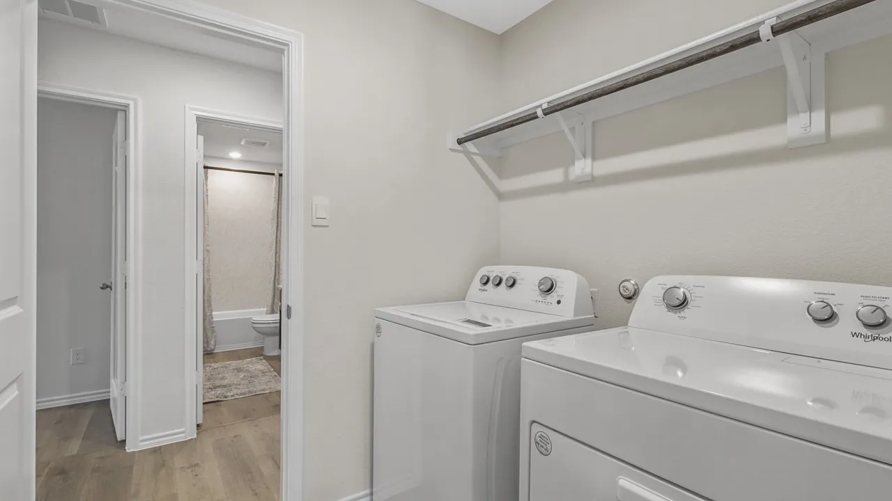 Dedicated laundry area featuring a white top-load washer and front-load dryer