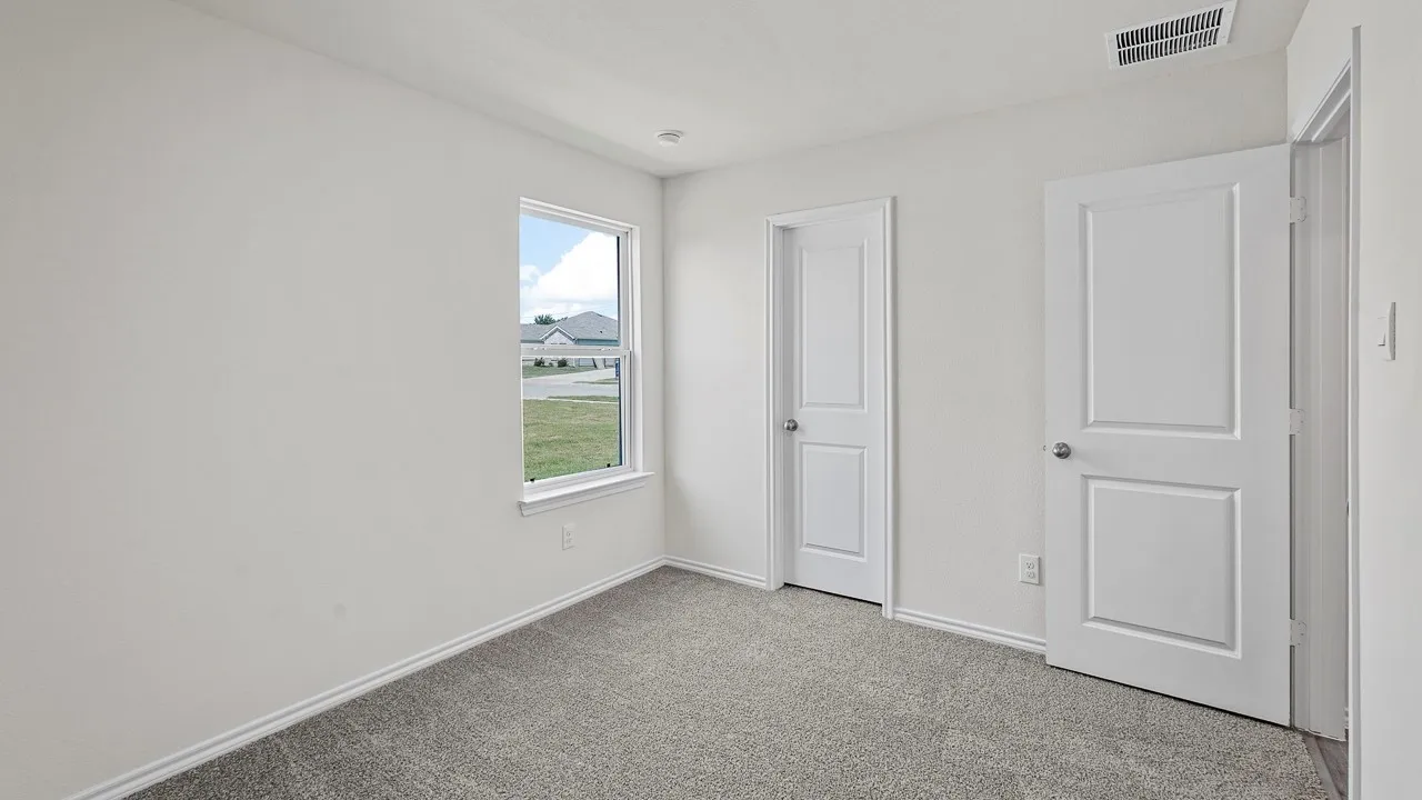 Carpeted interior room with white walls