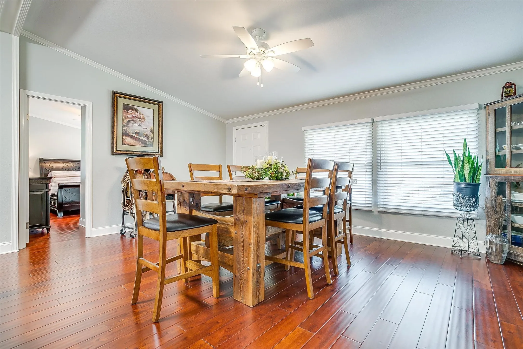 Hardwood-finish flooring throughout, crown molding details, and a ceiling fan with light fixture
