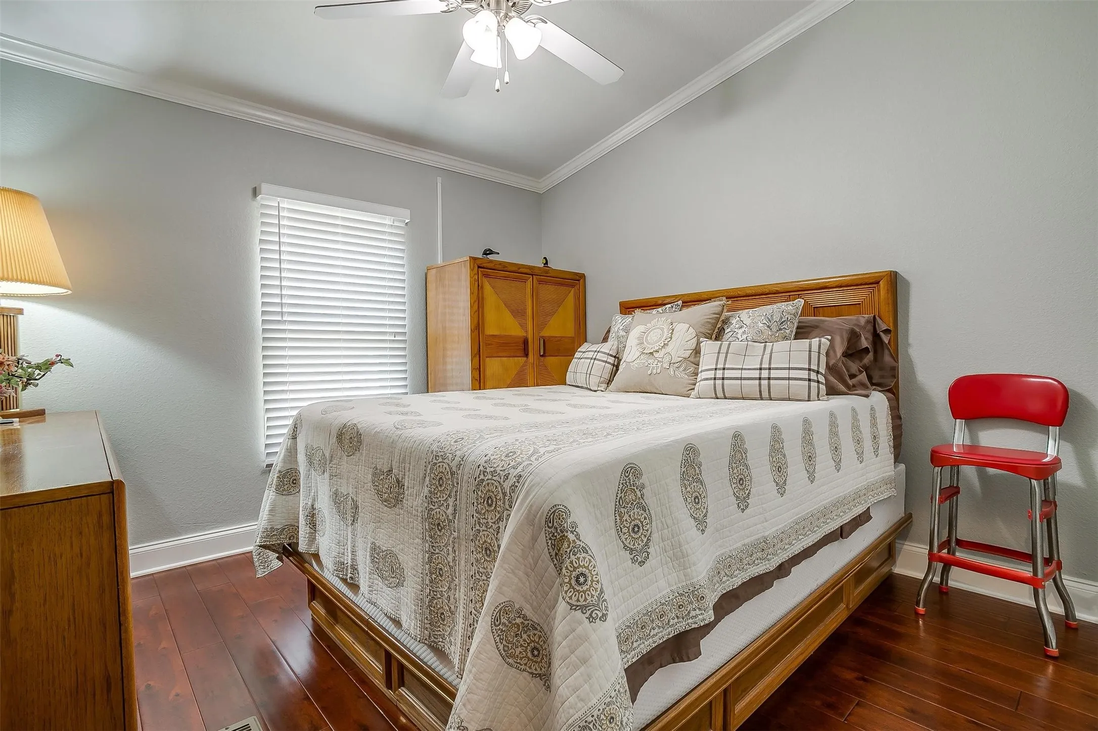Bedroom featuring wood-finish flooring, light gray walls, and white crown​​‌​​​​‌​​‌‌​‌‌​​​‌‌​‌​‌​‌​​​‌​​ molding