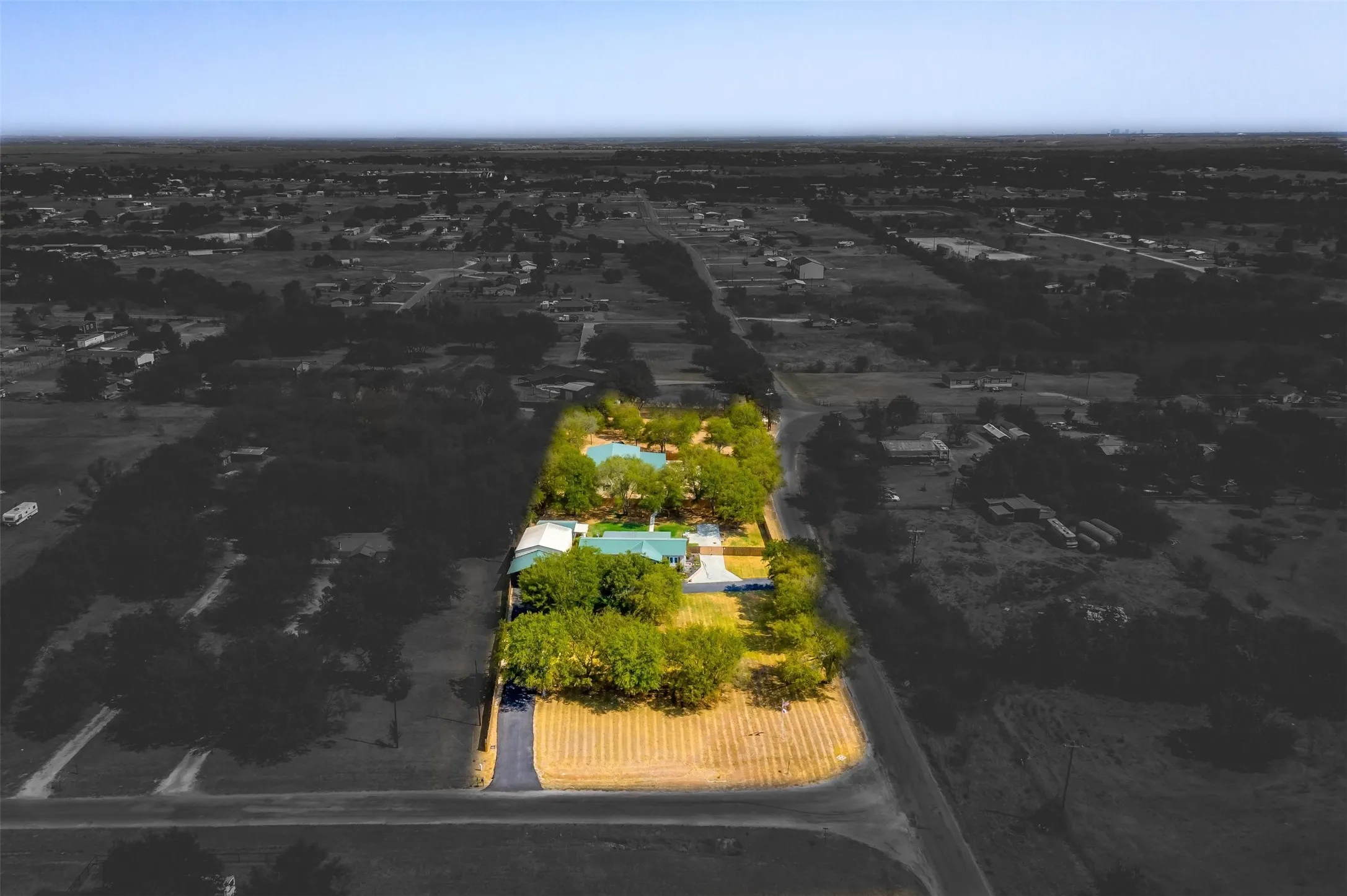 Expansive property featuring multiple structures, mature trees, a private driveway, and a spacious lot