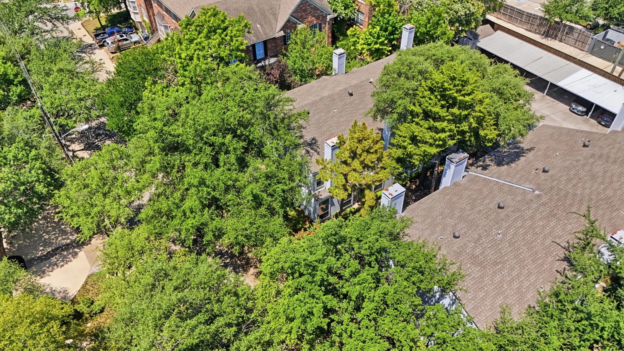 Aerial perspective highlighting the property's rooflines, several chimneys, and a covered parking structure
