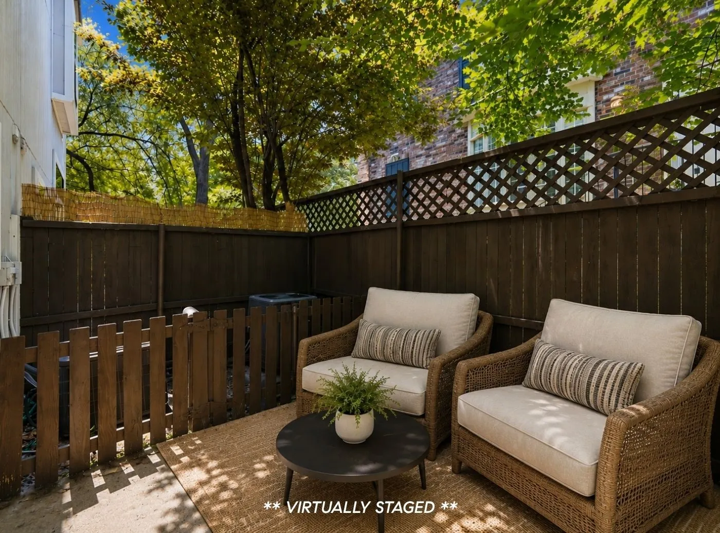 Private outdoor patio space featuring dark wood fencing with lattice top details