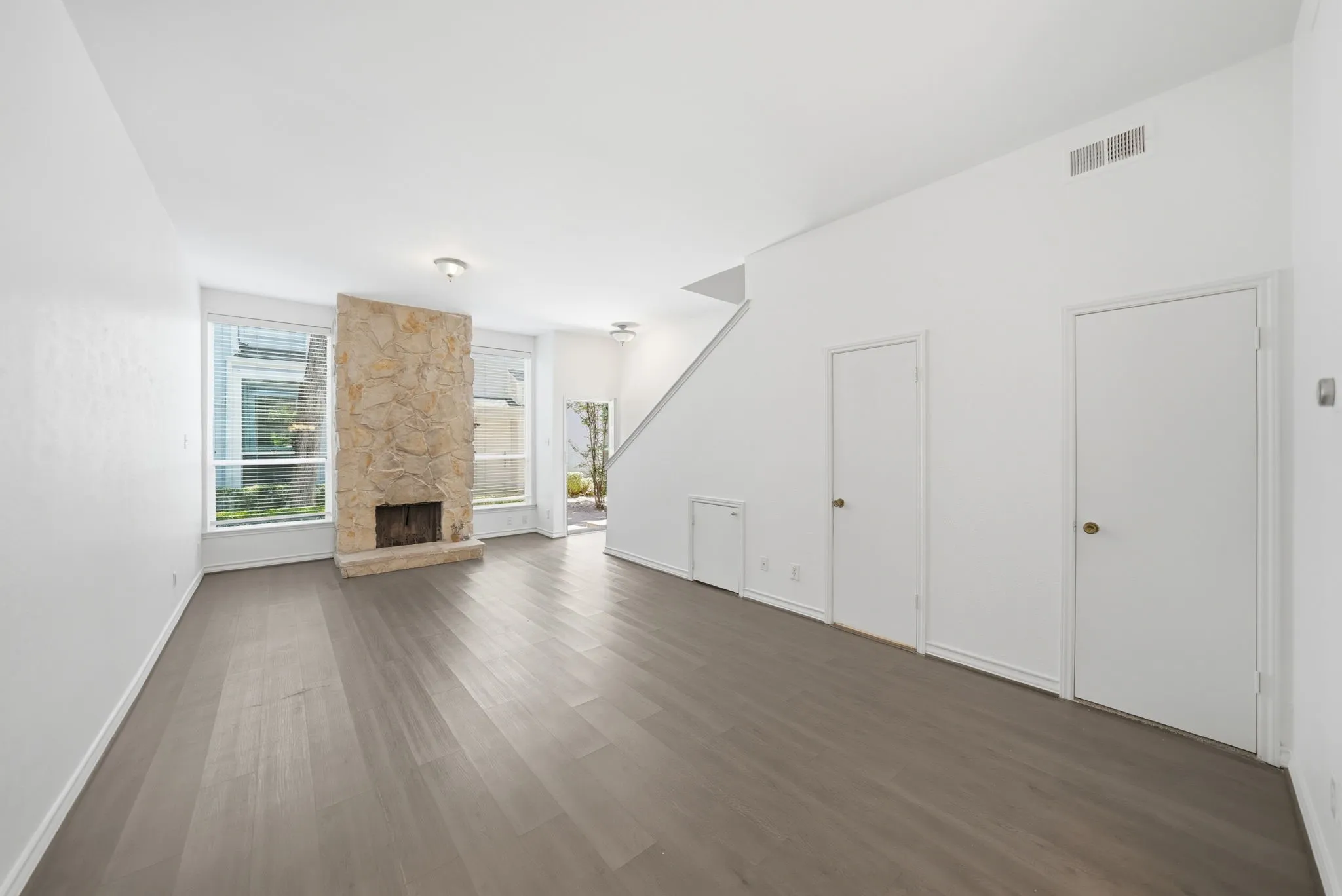 Living area featuring a stone-clad fireplace and wood-finish flooring