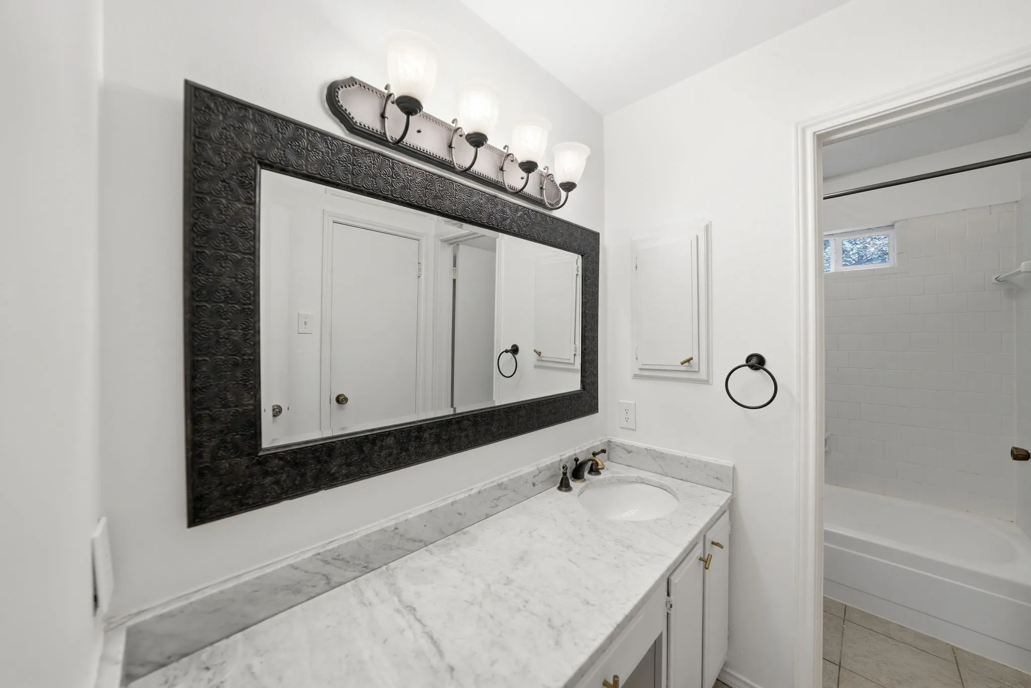 Vanity with white marble-finish countertop and undermount sink