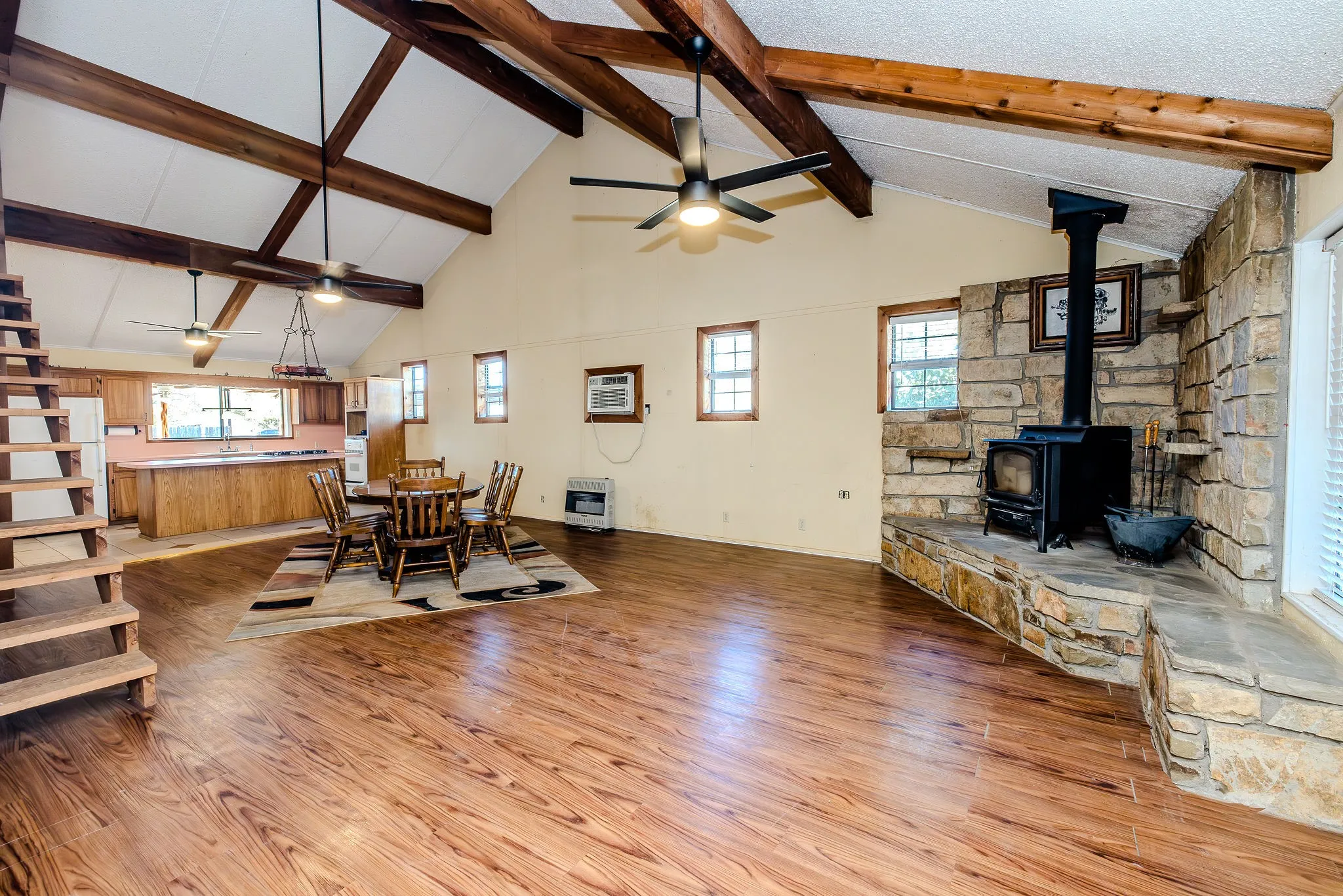 Entry view is this spacious open floor plan with large living area, wood burning stove, and cathedral ceilings.