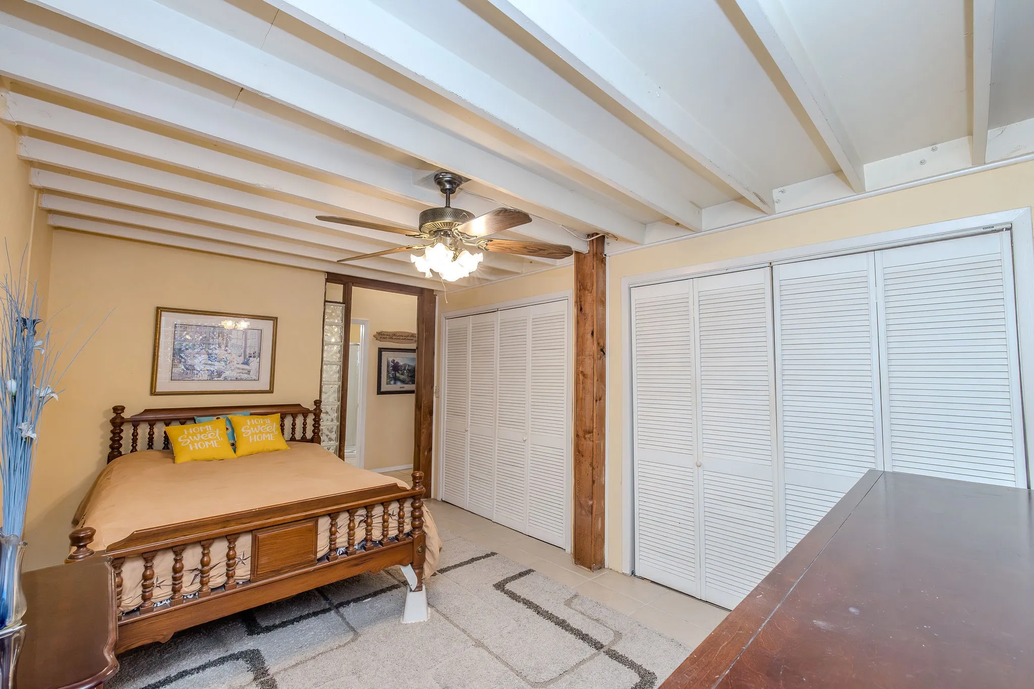 Large main level bedroom with tile flooring serves as the primary bedroom and features double closets on one wall.