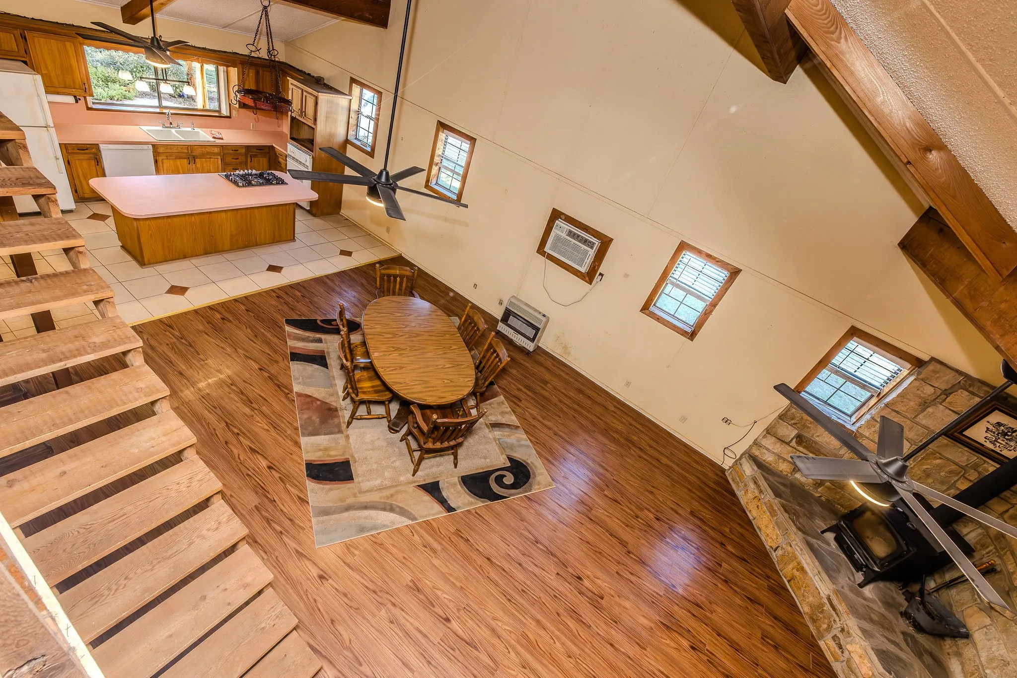 Loft view of kitchen, dining area, and living room. Note the height of this ceiling! Also, the gas wall furnace, window unit, and ceiling fan are ALL that's needed to heat or cool this very well insulated home (6" styrofoam walls!).