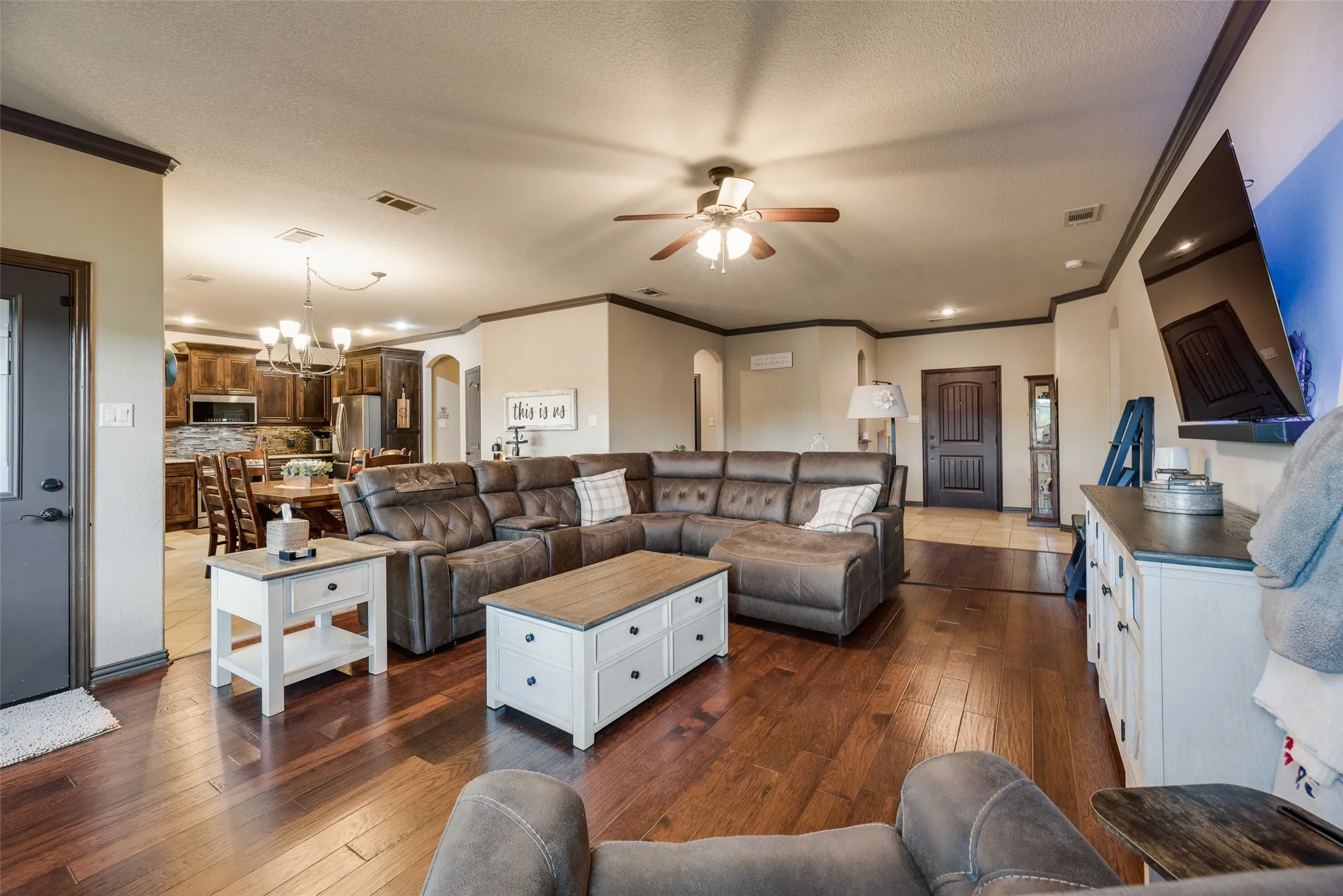Spacious living area featuring wood-finish flooring, recessed lighting, and a ceiling fan