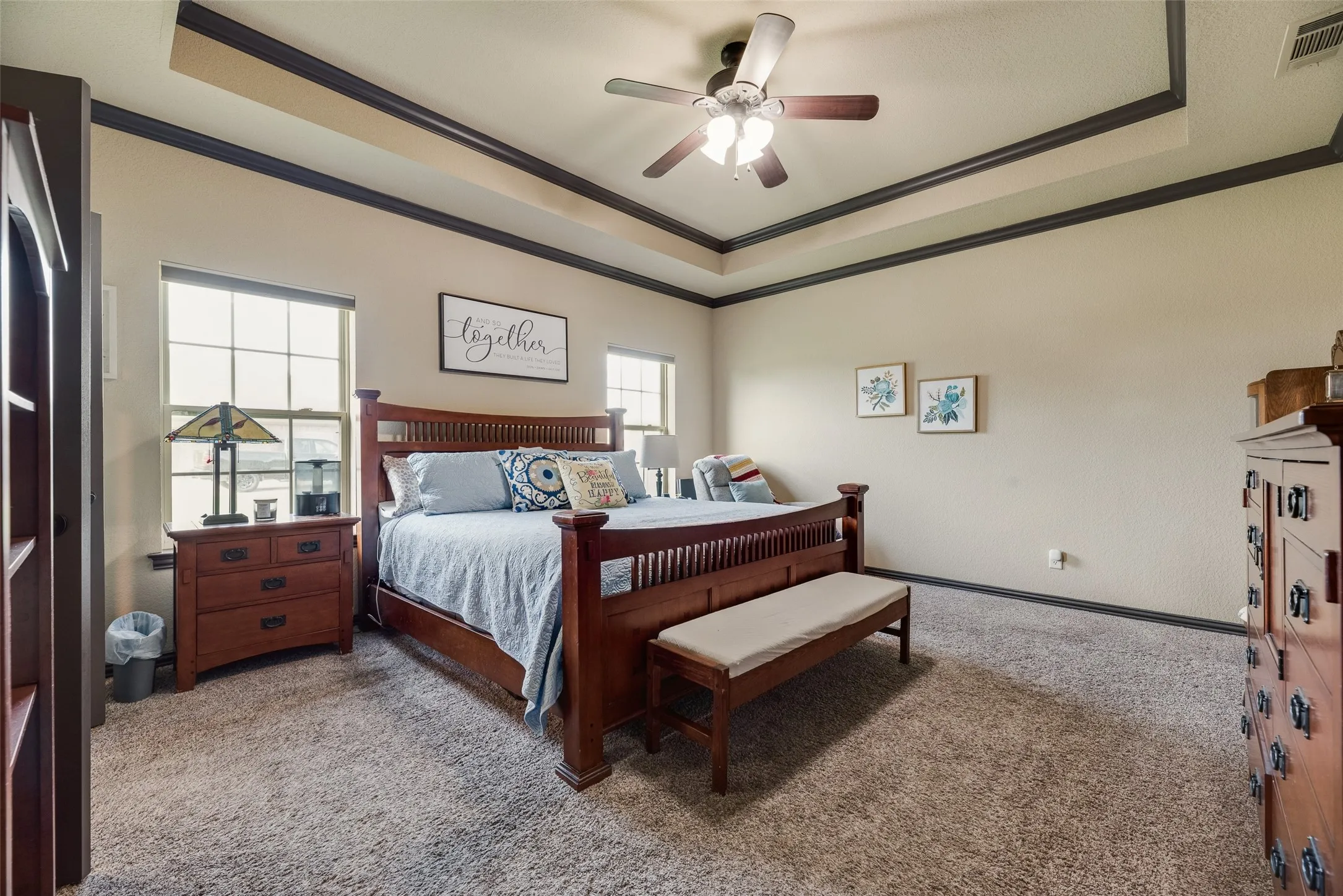 Spacious room featuring a tray ceiling with dark trim, recessed lighting, and a ceiling fan