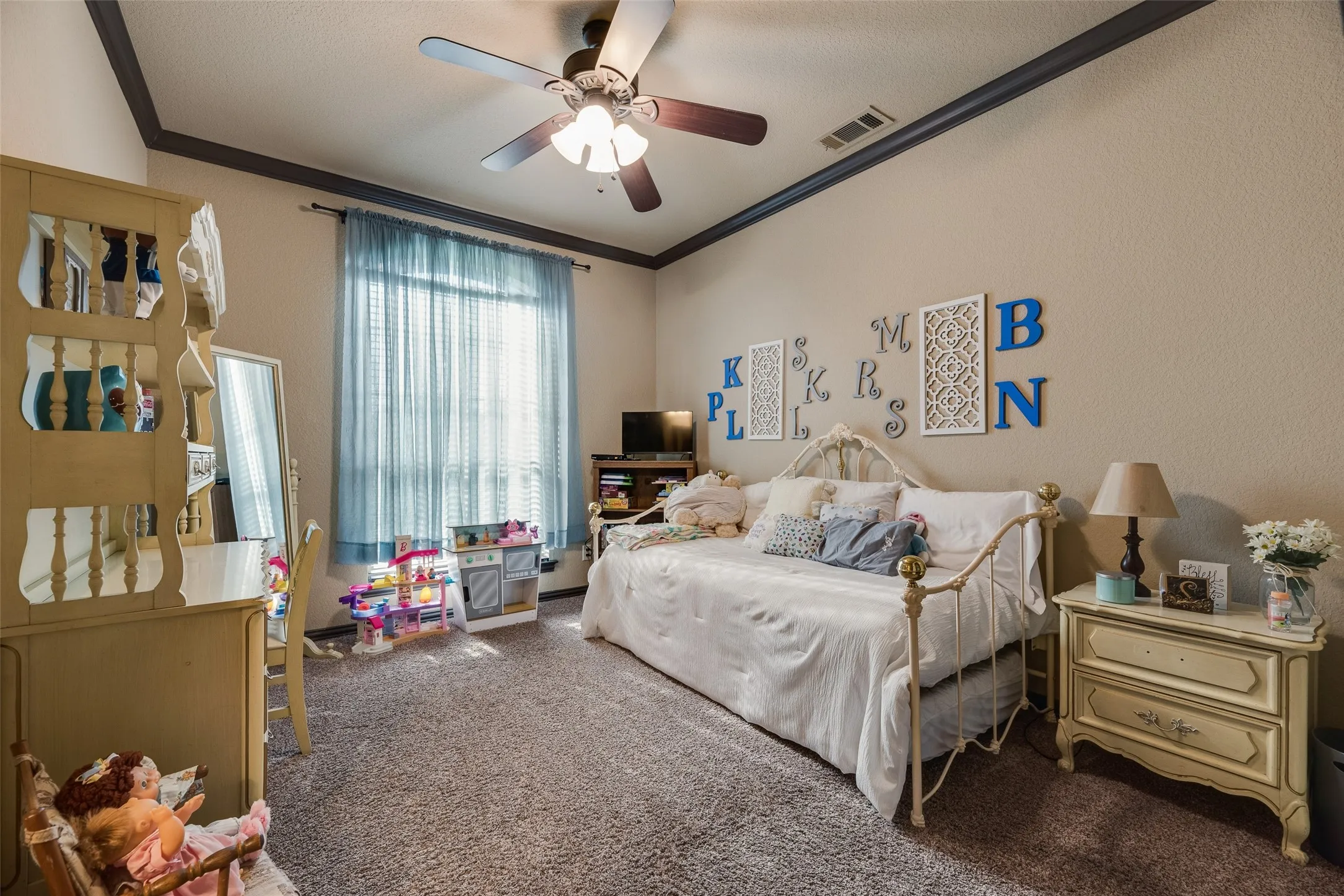 Spacious room featuring textured walls with crown molding, a ceiling fan with integrated lighting, and a large window with vertical blinds