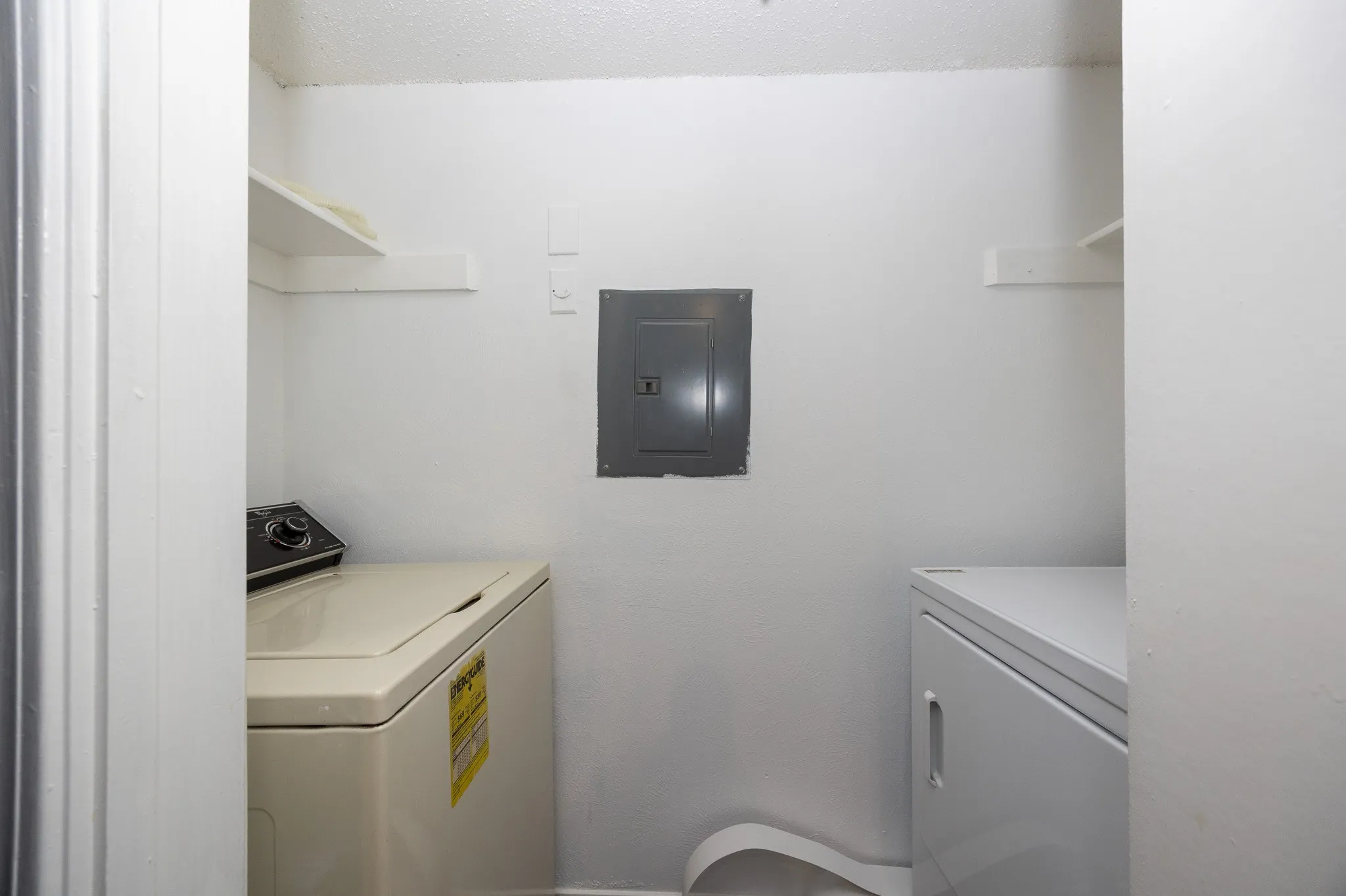 Utility area featuring wall shelving and a circuit breaker panel