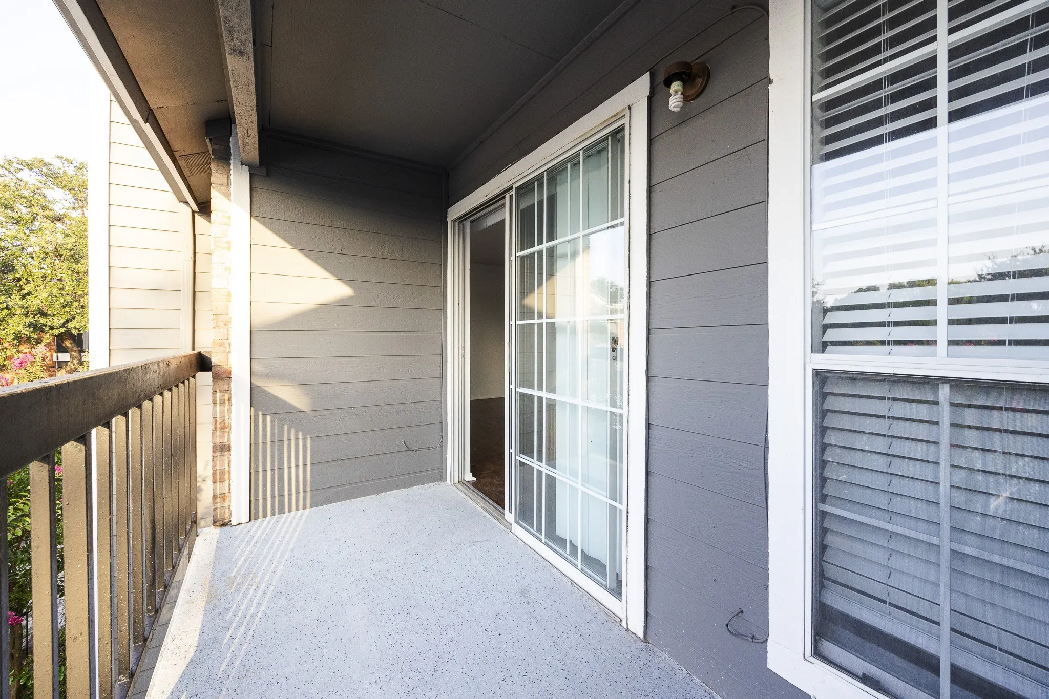 Balcony featuring a sliding glass door, white window frames, horizontal siding, and a wooden railing