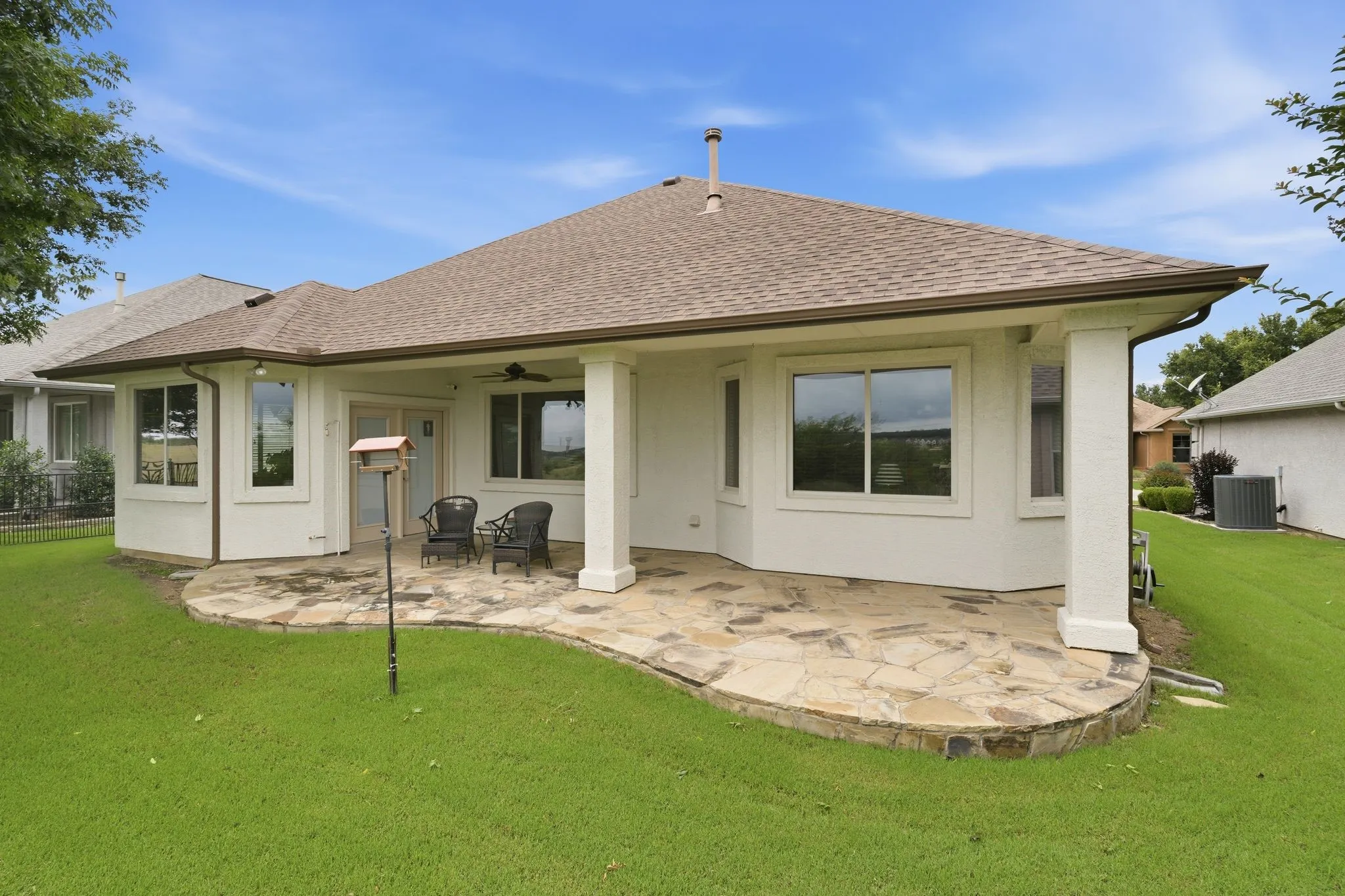 Expansive flagstone patio with a covered area and ceiling fan