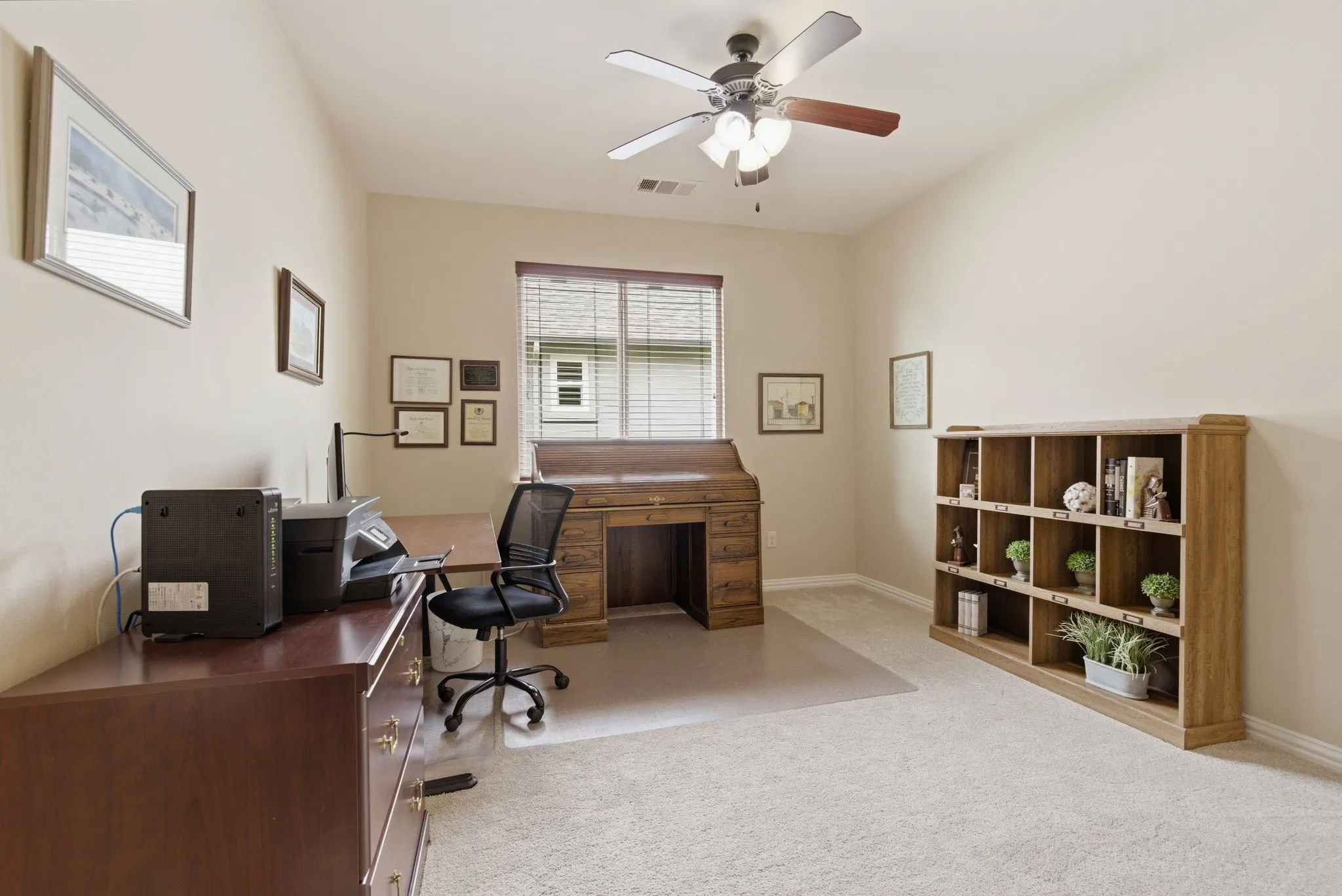 Carpeted room featuring a ceiling fan with light fixture, a window with blinds, and light-colored walls