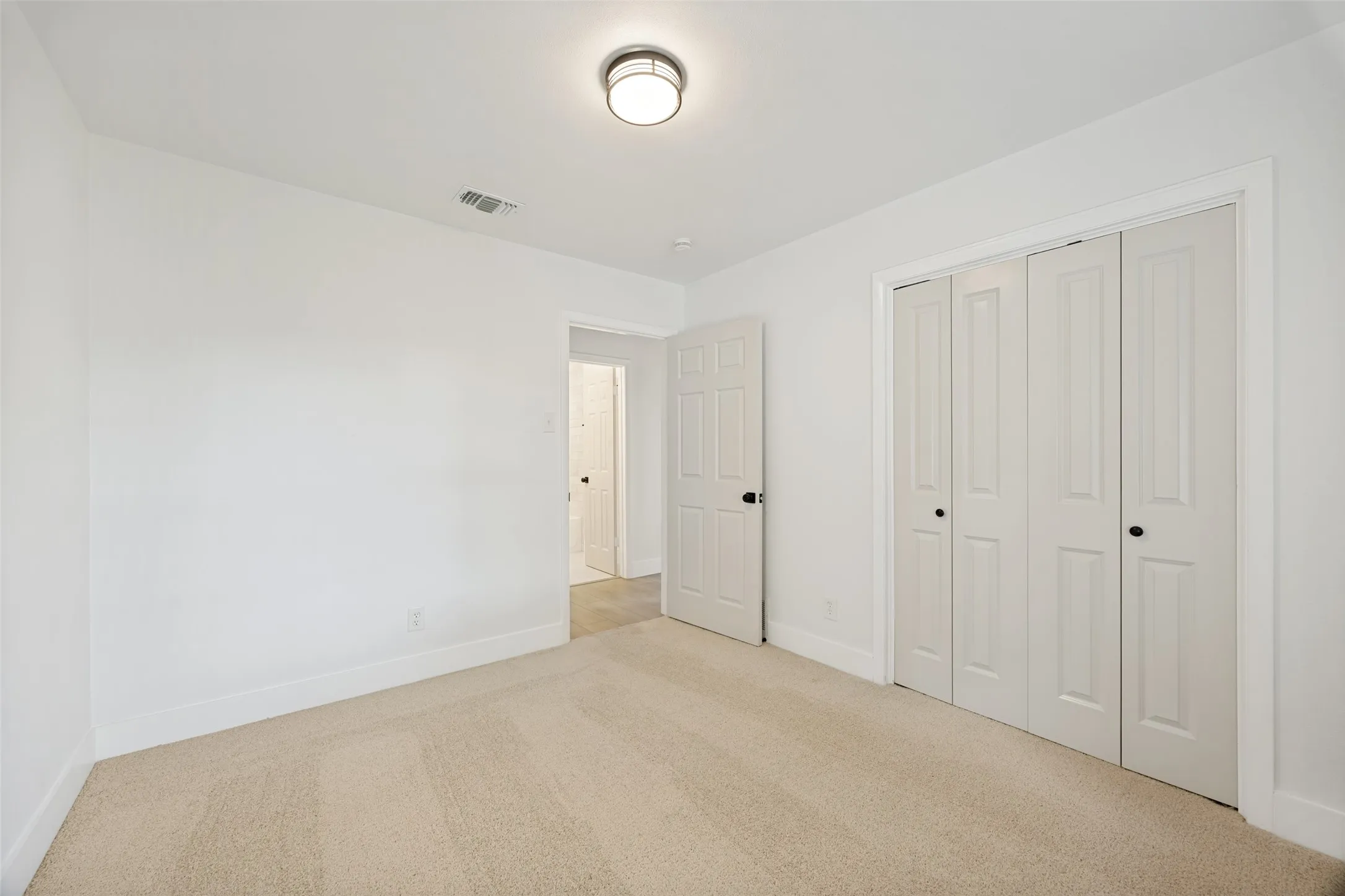 Neutral-toned carpeting paired with white walls, baseboards, and trim