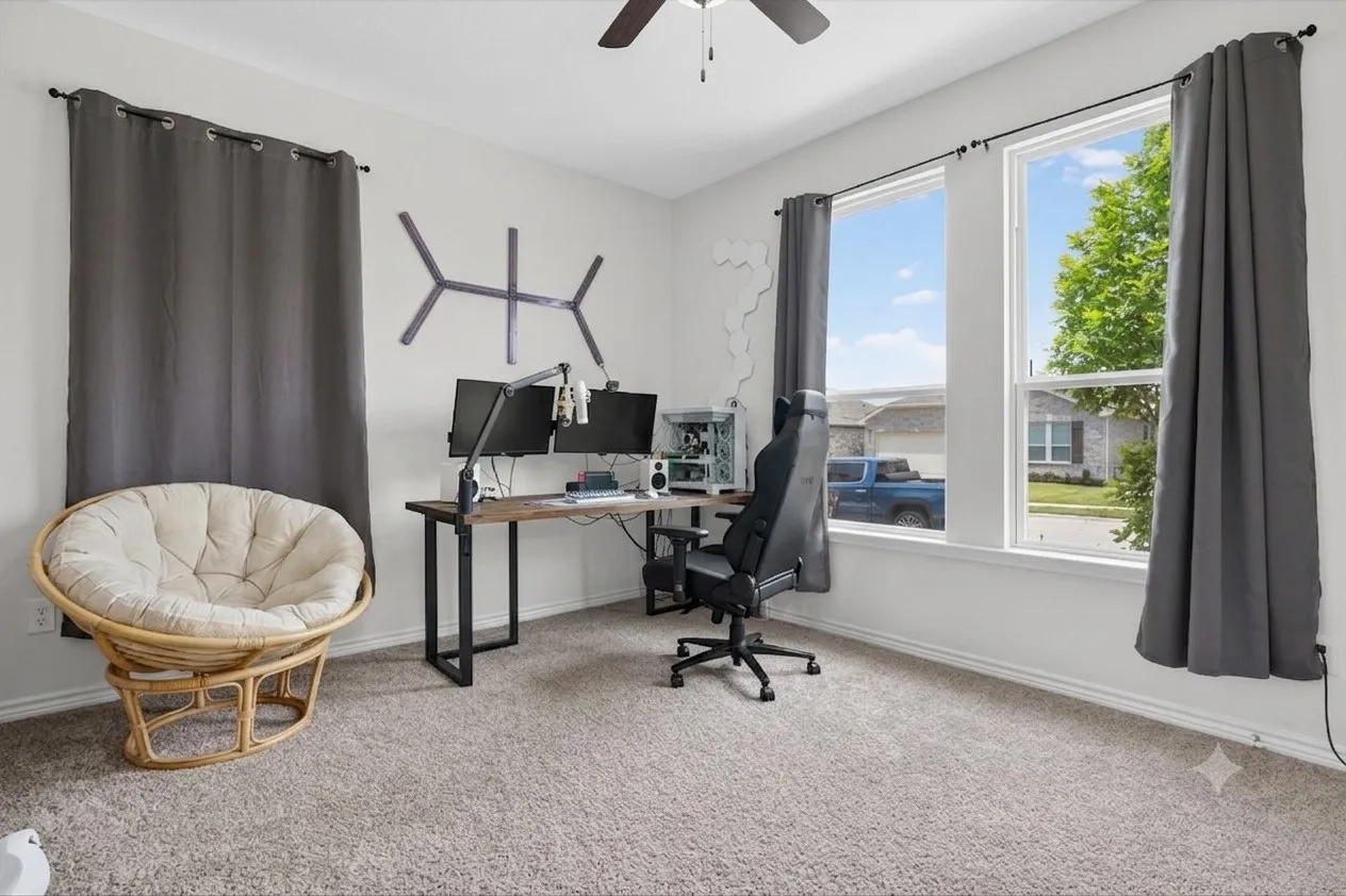 Carpeted room with a ceiling fan, two large windows, and neutral wall tones
