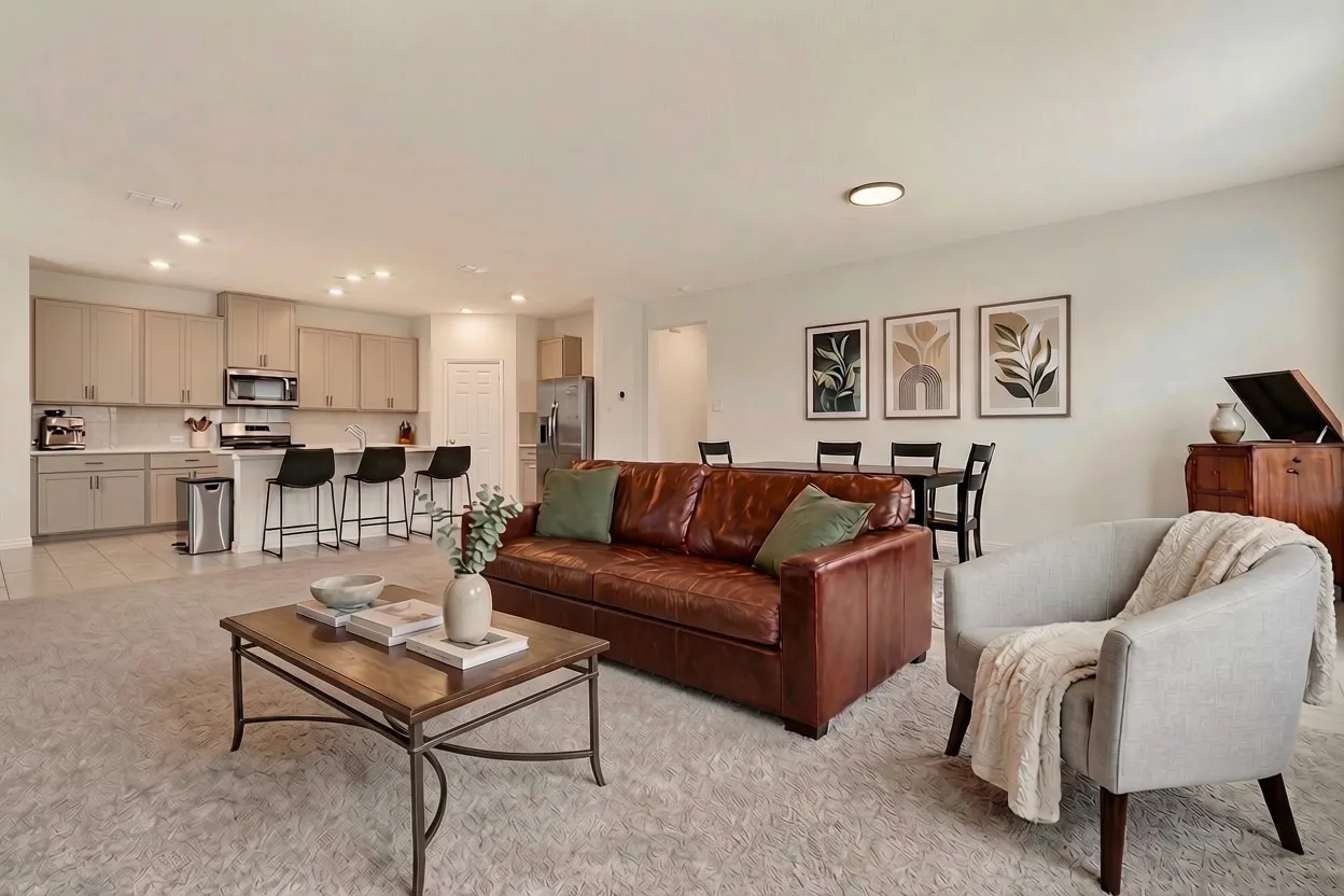 Open-concept living space featuring recessed lighting, light-toned walls, and a kitchen with light grey cabinetry, stainless steel appliances, and white countertops