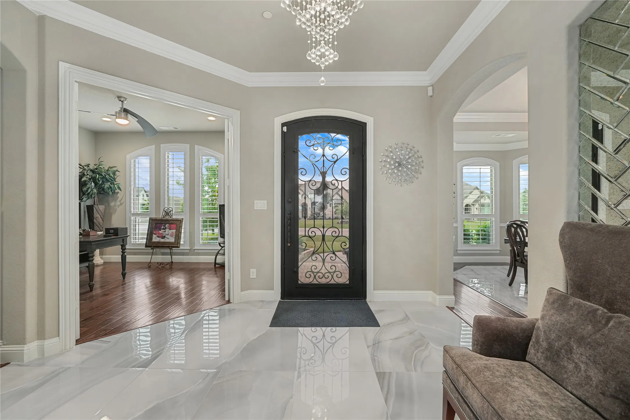Grand entry featuring polished marble-look flooring and a wrought iron entry door