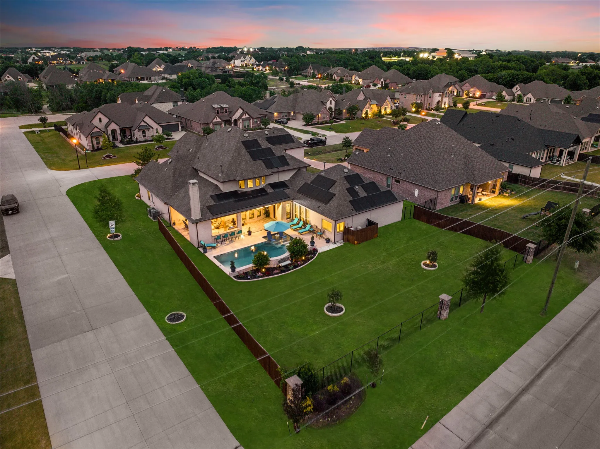 Expansive property featuring a large in-ground swimming pool, a spacious green lawn, and a covered patio area