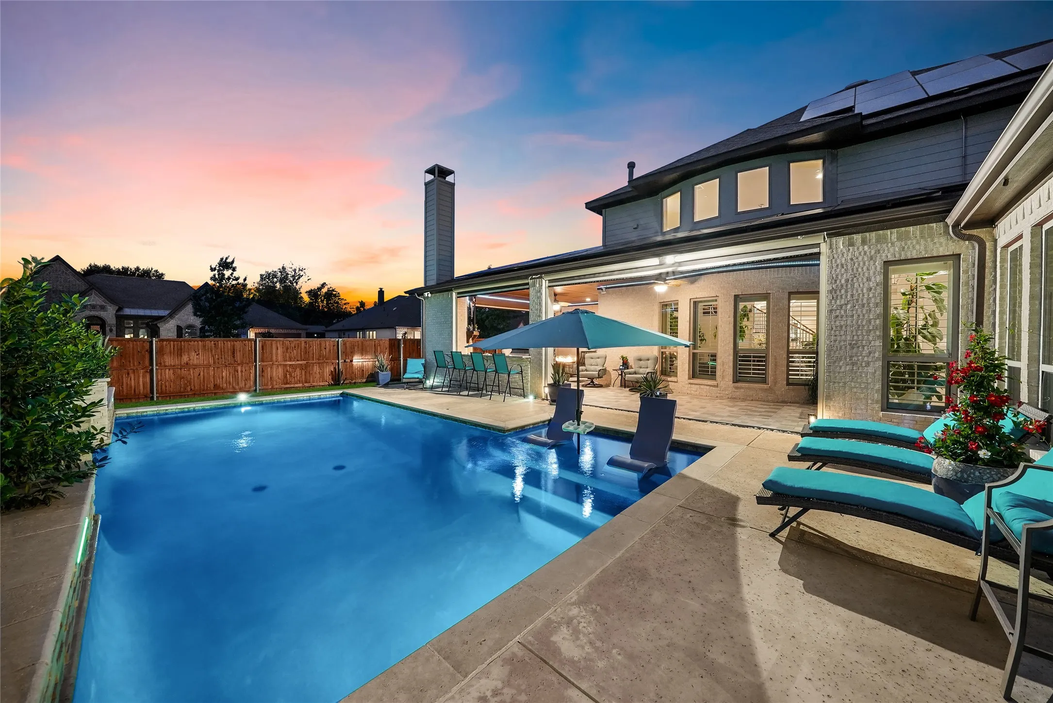 Resort-style backyard featuring a spacious swimming pool with an integrated spa, a substantial concrete patio, and a covered outdoor living area