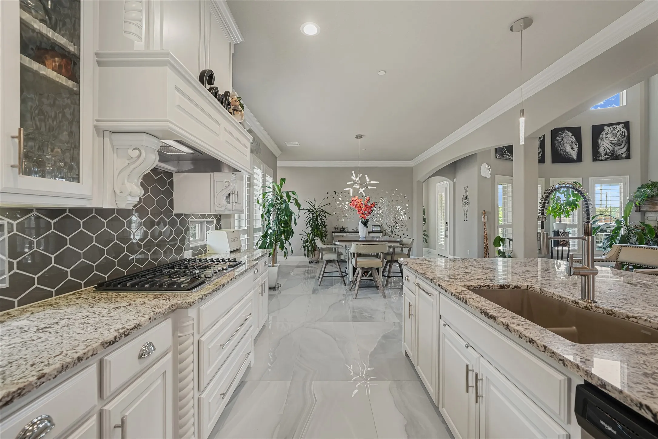 Gourmet kitchen featuring a built-in gas range, hexagonal tile backsplash, granite countertops, an undermount sink, and white cabinetry