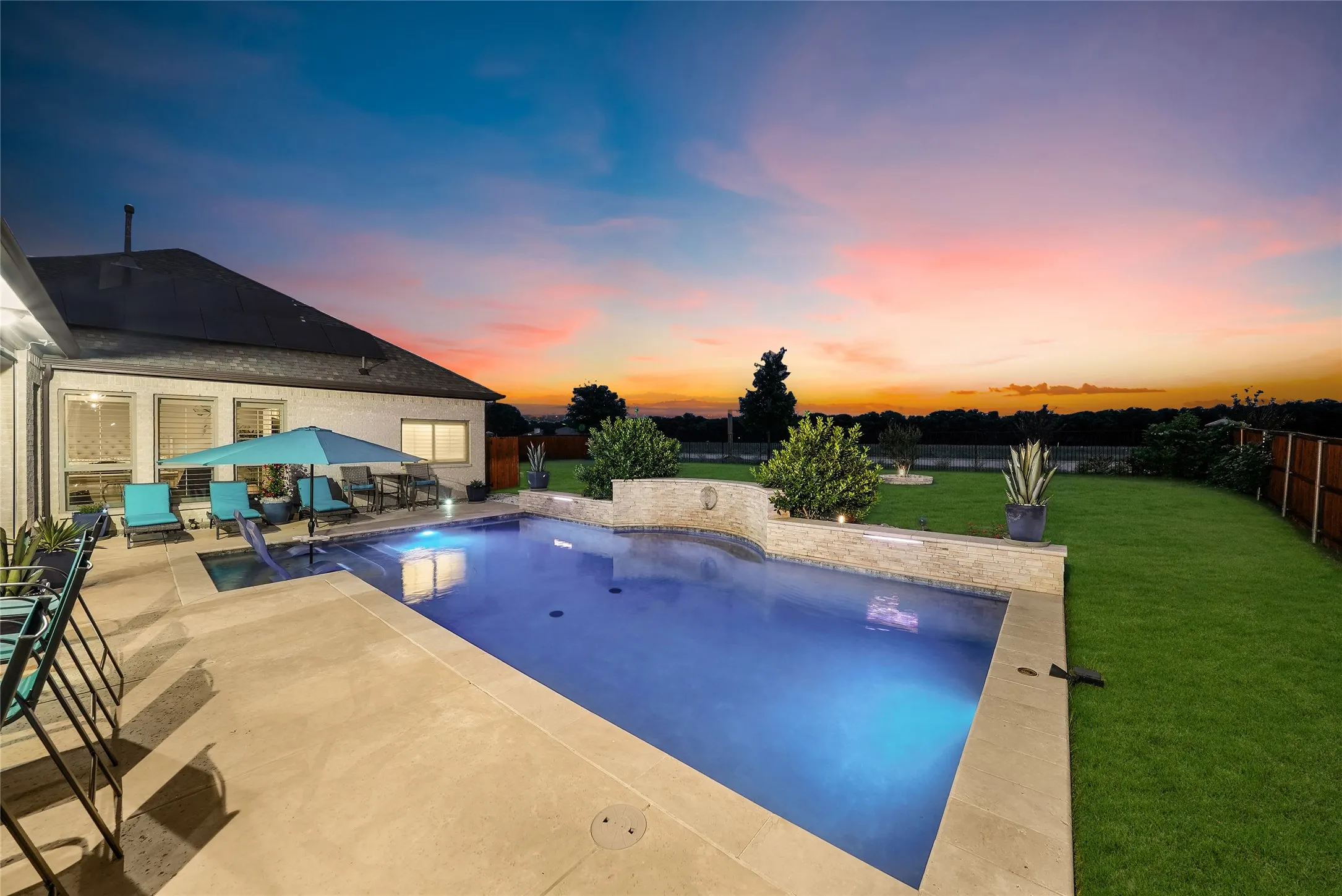 Rear exterior featuring a swimming pool, concrete patio, and manicured lawn