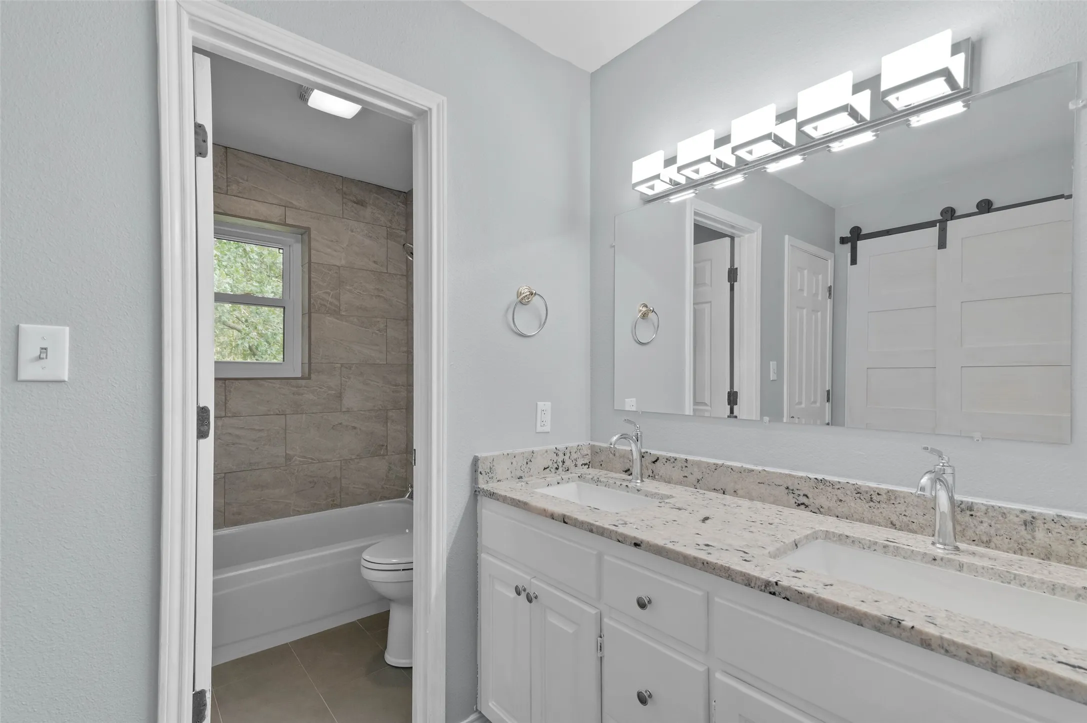 Primary bathroom features granite countertops, dual sinks and two closets.