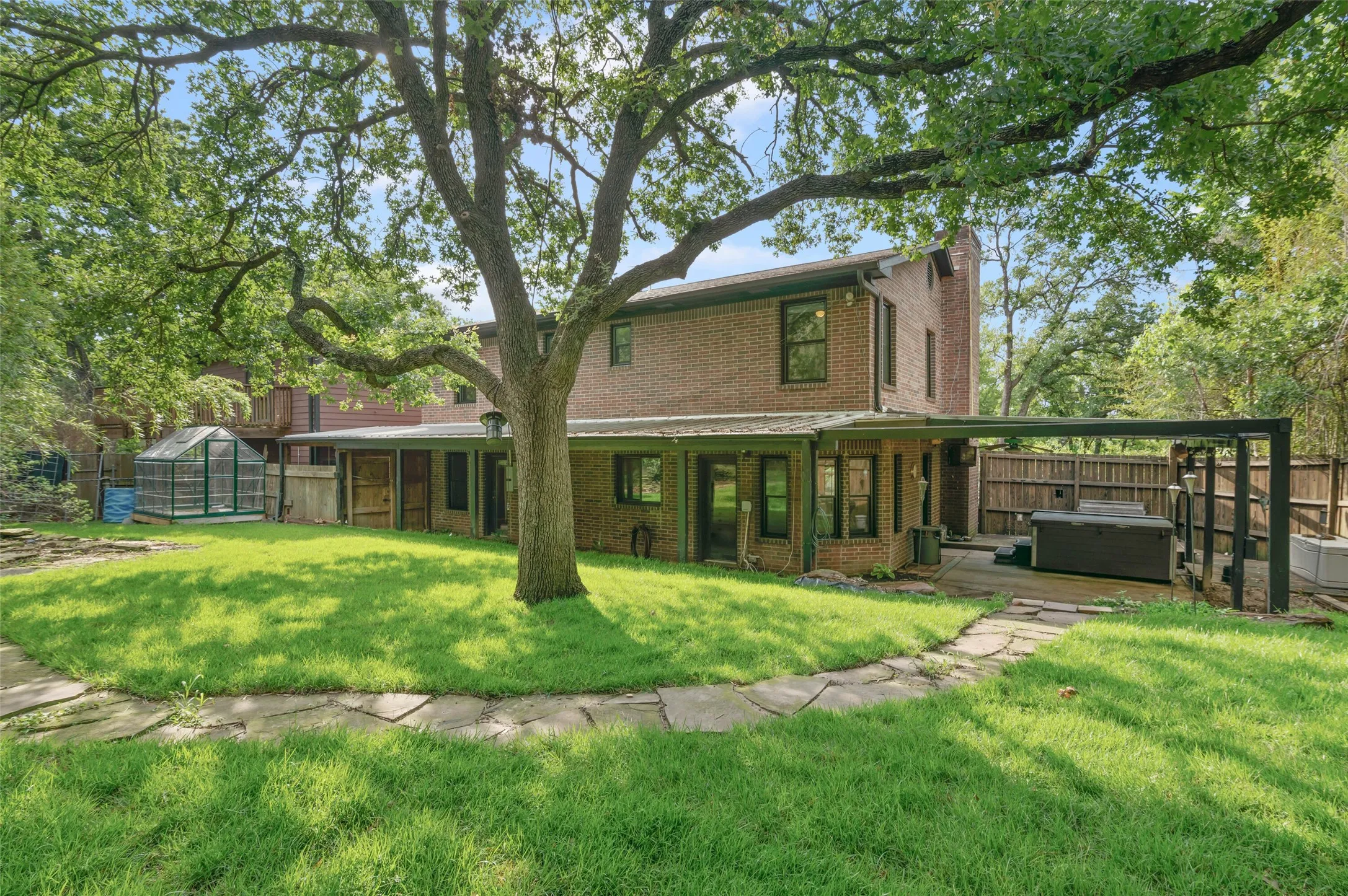 What a great back yard! Secluded backyard, large grassy area and a covered patio with hot tub.