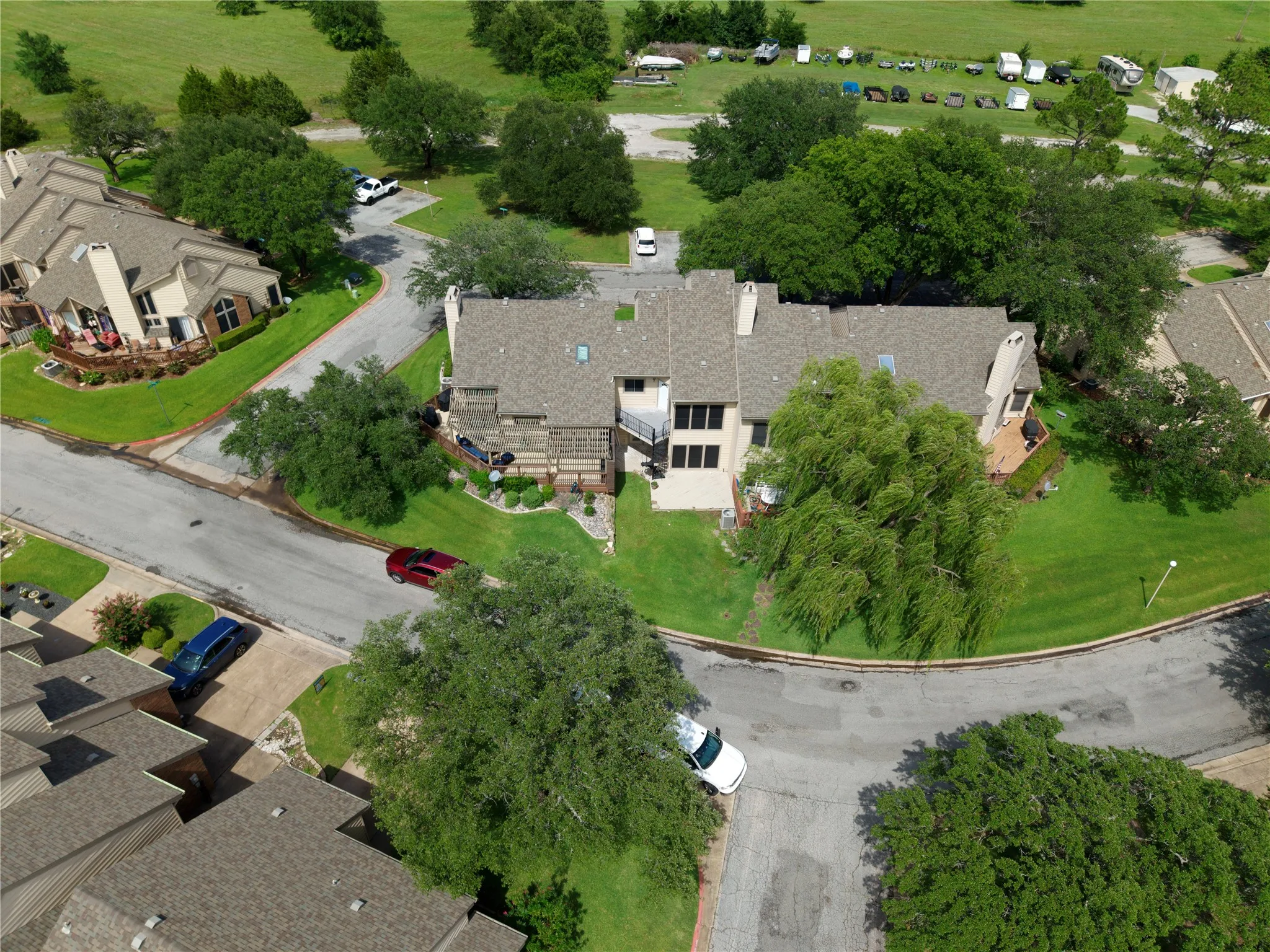 Aerial perspective showcasing a multi-level residential property with a shingled roof and multiple windows