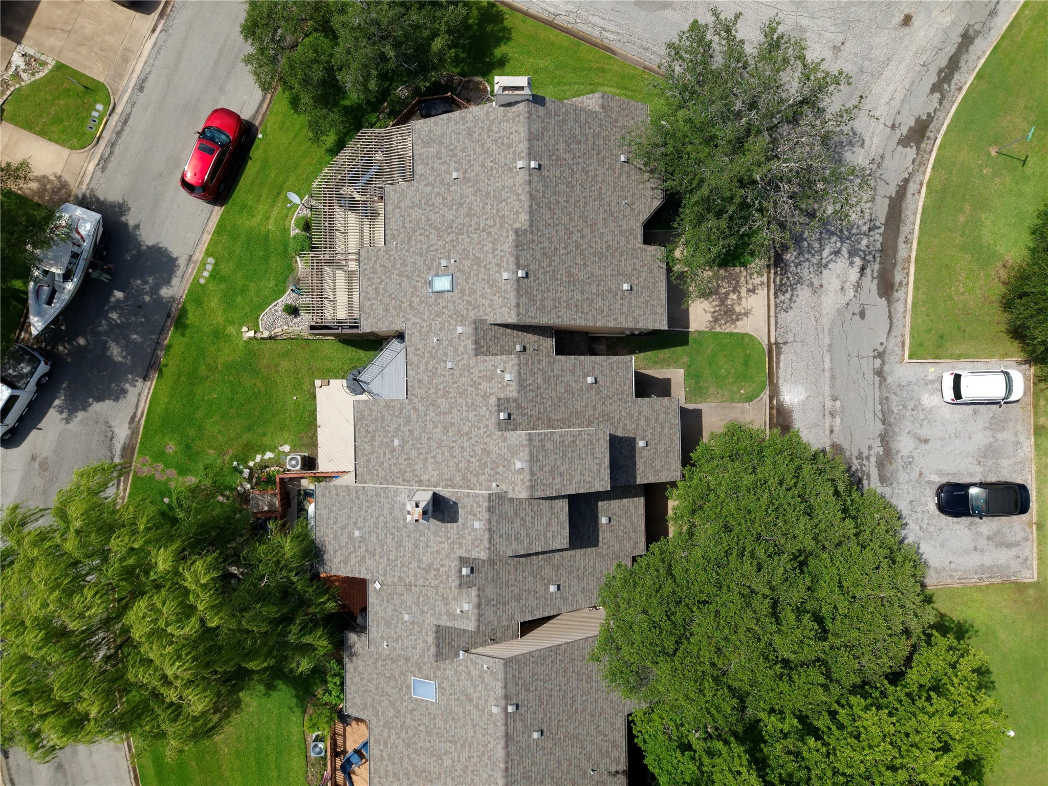 Multi-level residential roofing featuring asphalt shingles and skylights