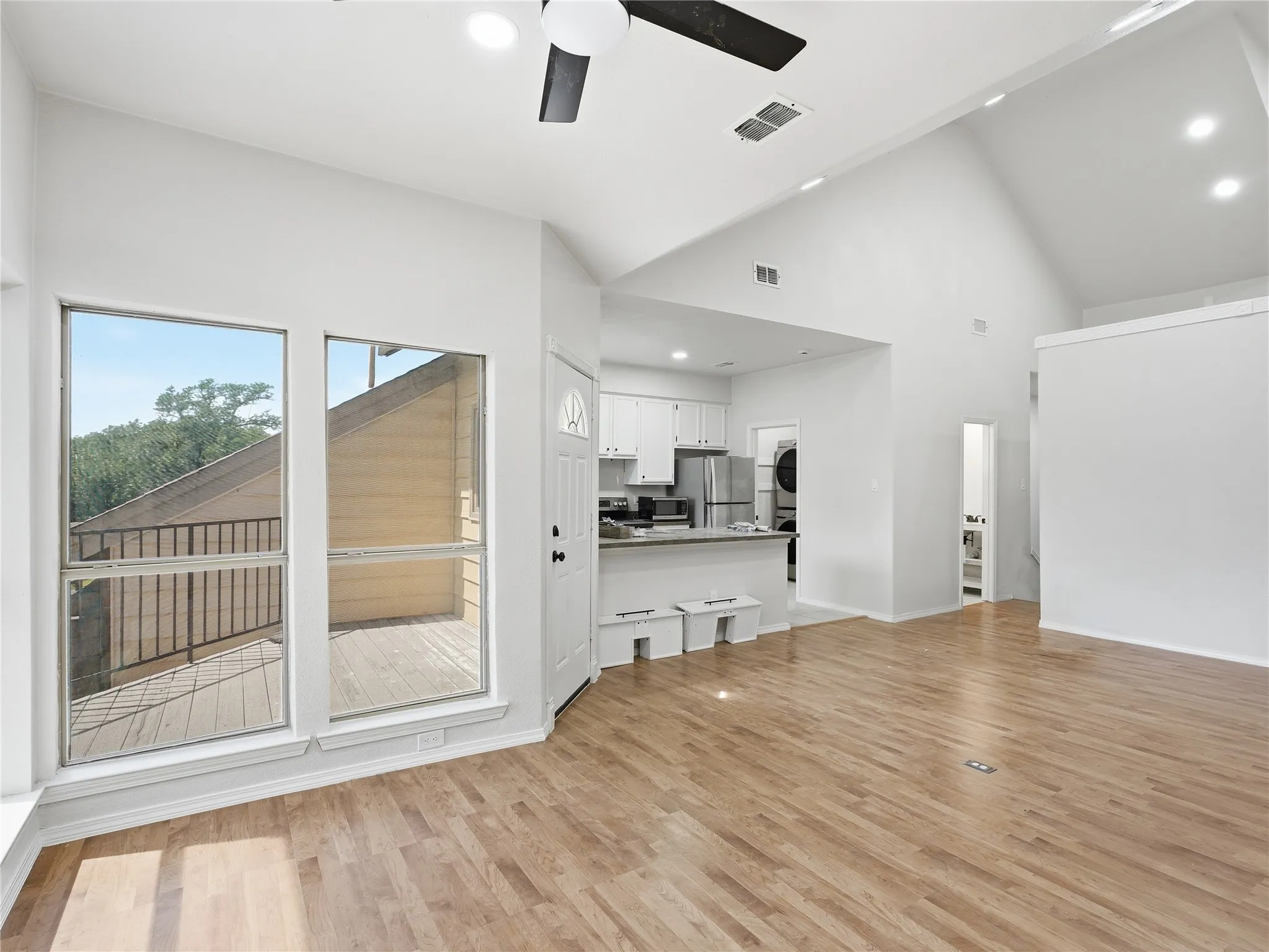 Vaulted ceilings with recessed lighting and a ceiling fan