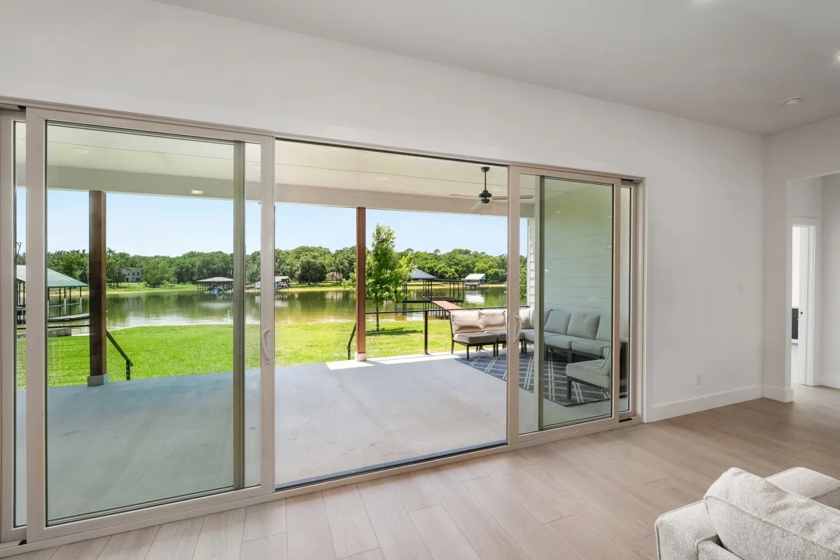 Open-concept living, dining & kitchen with panoramic water views & slider door.