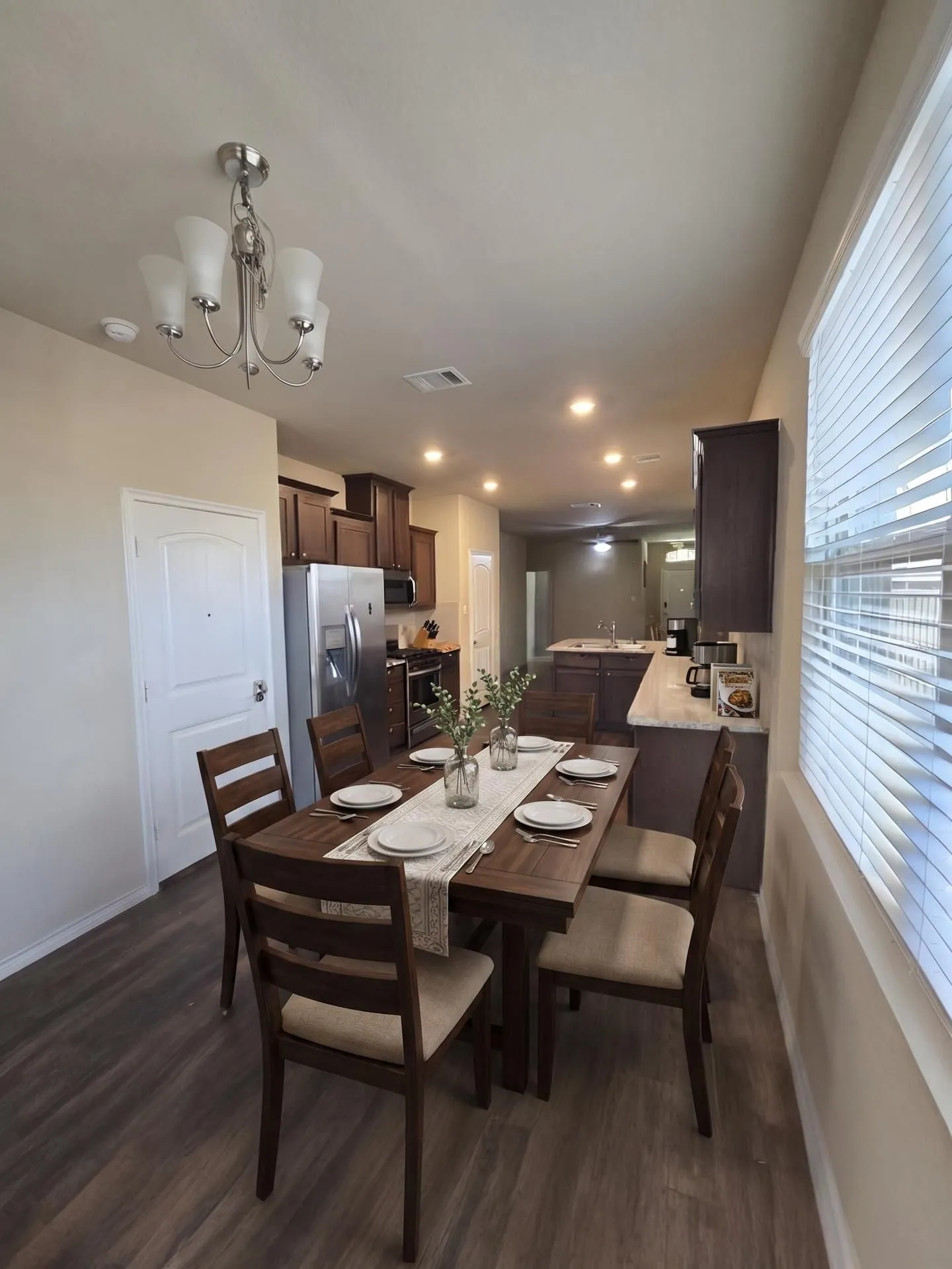 Dining area featuring wood-finish flooring, a contemporary chandelier, and recessed lighting