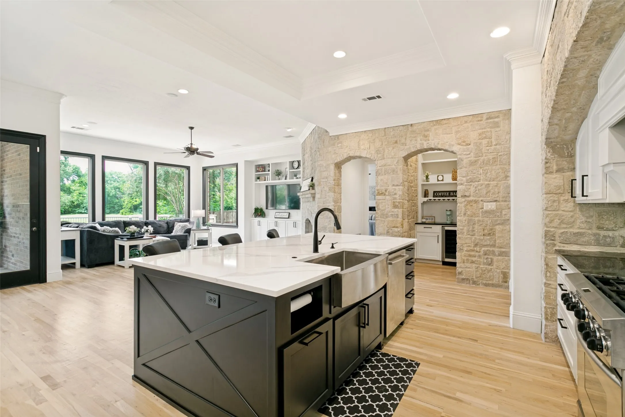 Gourmet kitchen with a large island featuring a farmhouse sink and light-toned countertops