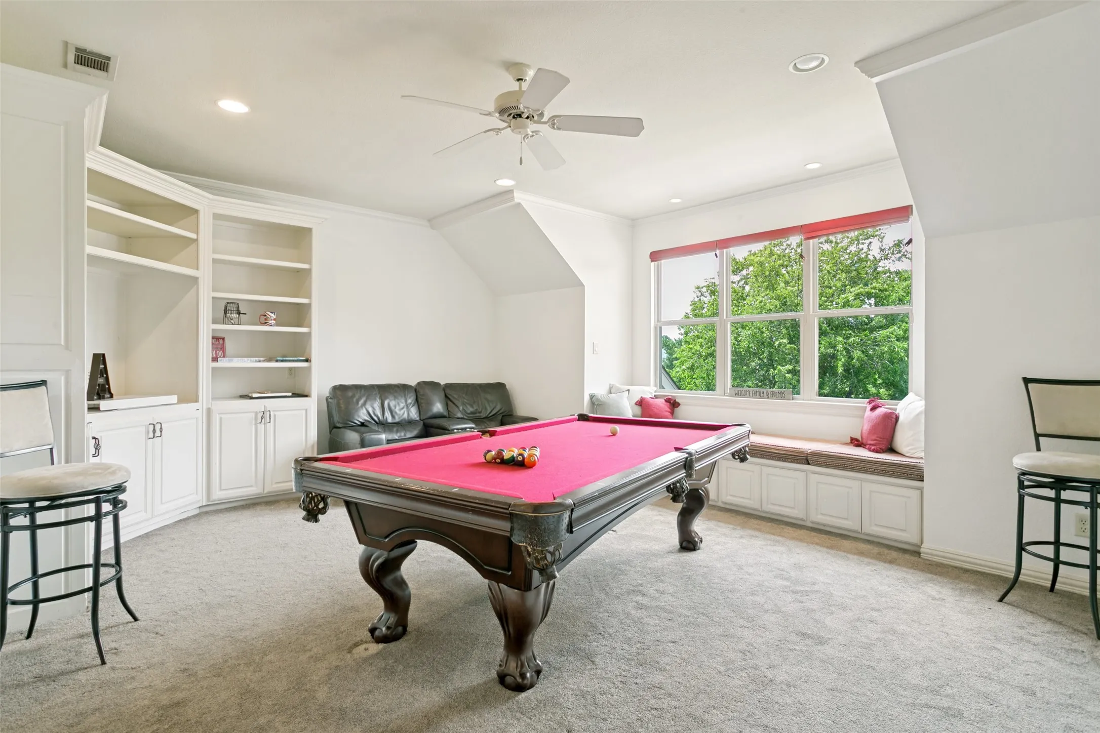 Game room featuring a built-in window bench, custom cabinetry with shelving, recessed lighting, and a ceiling fan