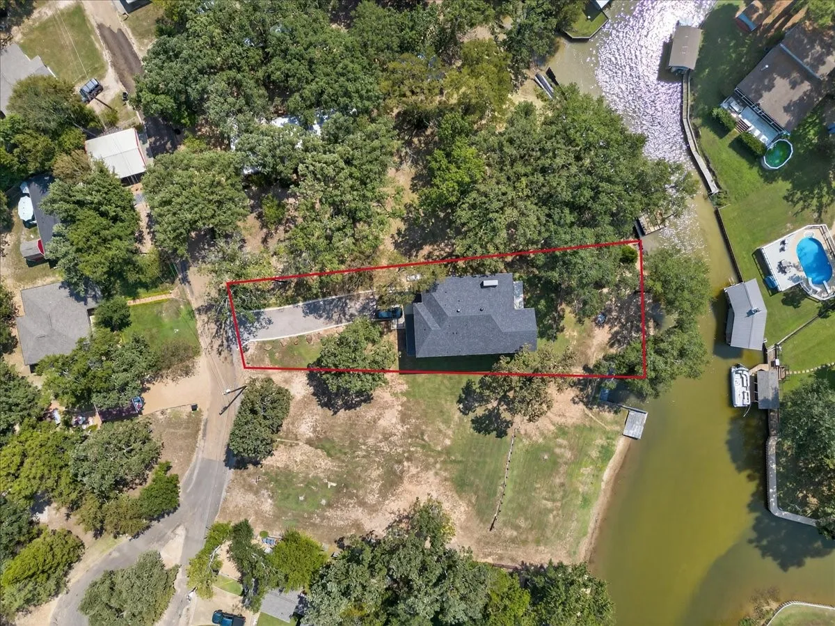 Aerial view showcasing the home's waterfront setting and nearly half-acre homesite.