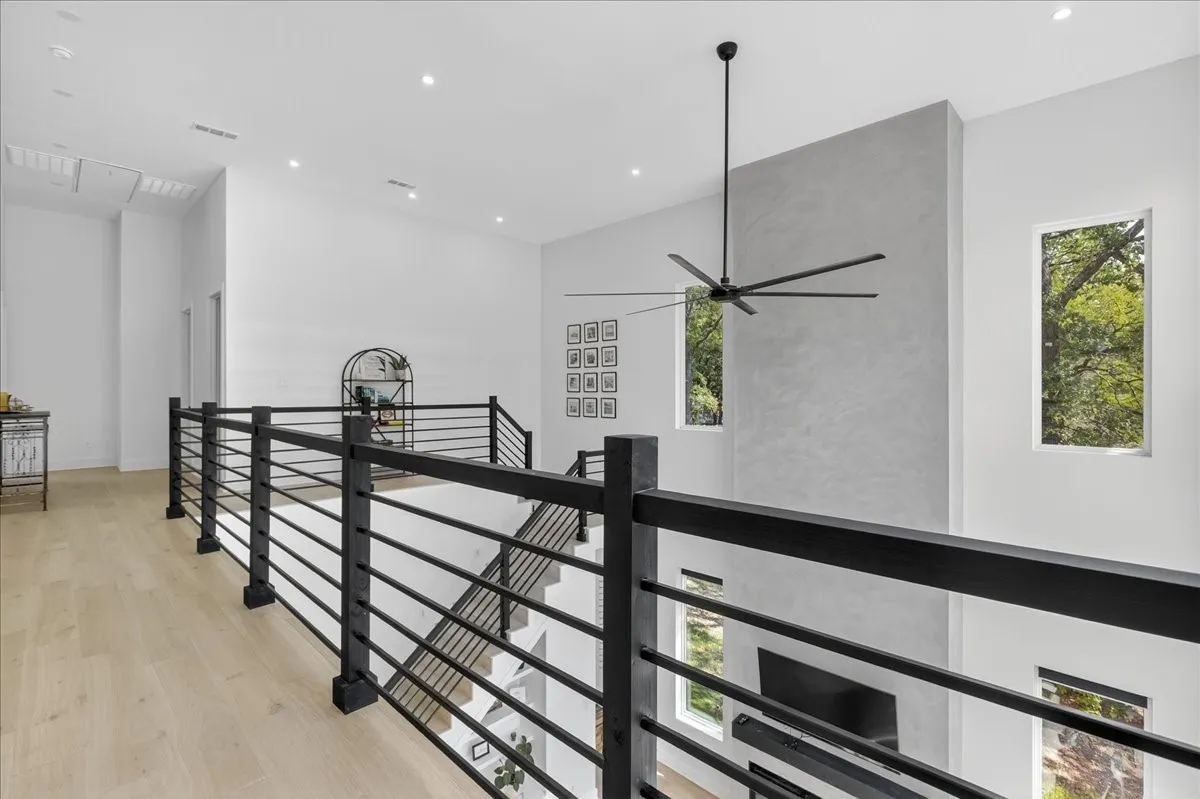 Expansive second-floor catwalk enhances the home's open-concept design. The plaster finish on the fireplace is lovely!