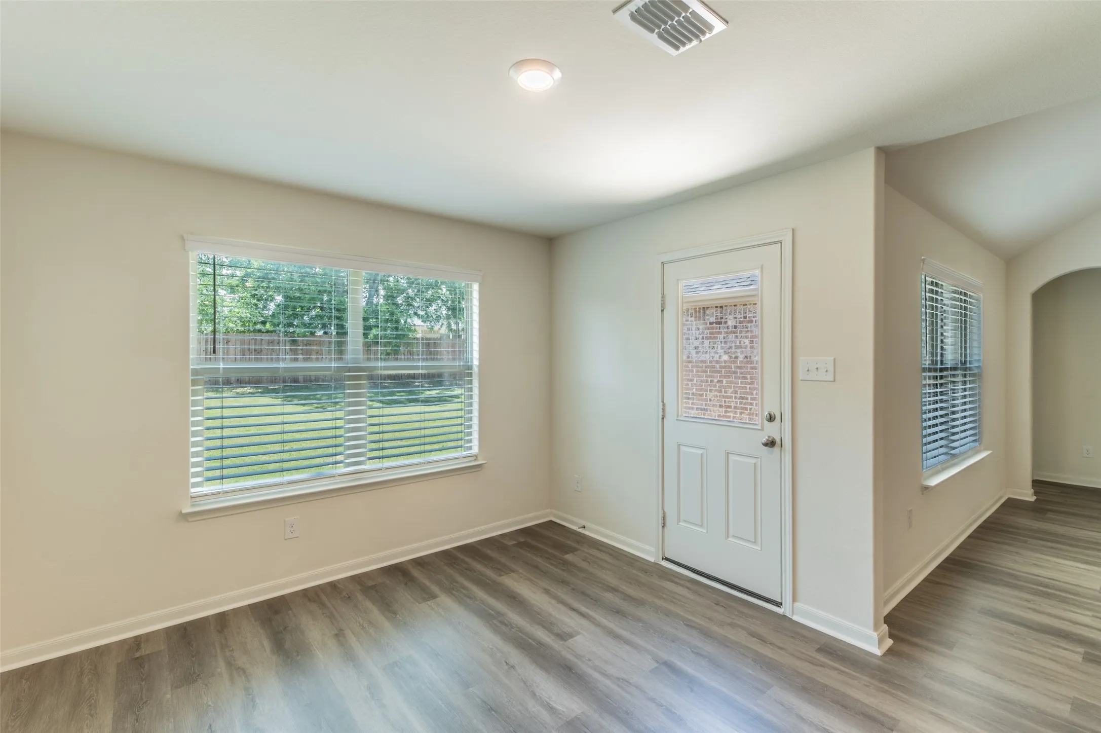 Dining area featuring wood-finish flooring, neutral wall tones, and white baseboards