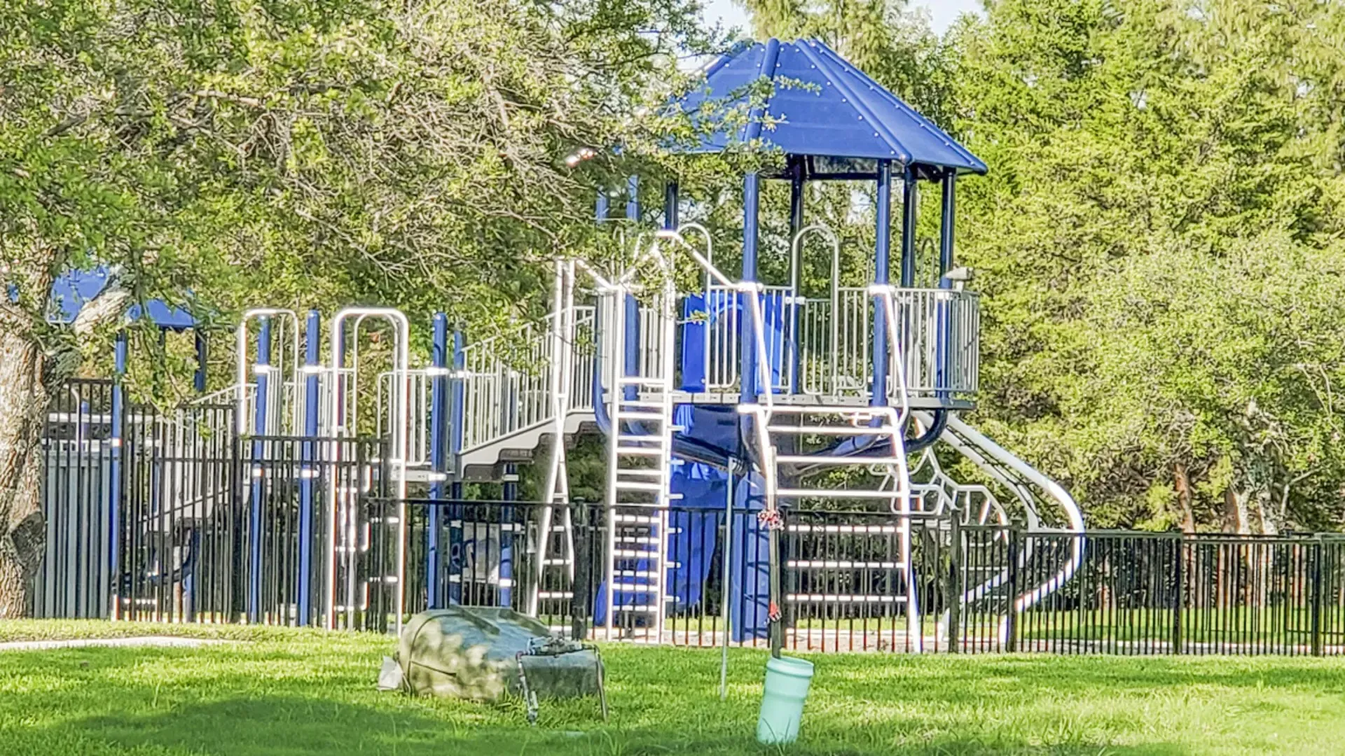 Playground area featuring blue and white structures, multiple slides, and climbing elements