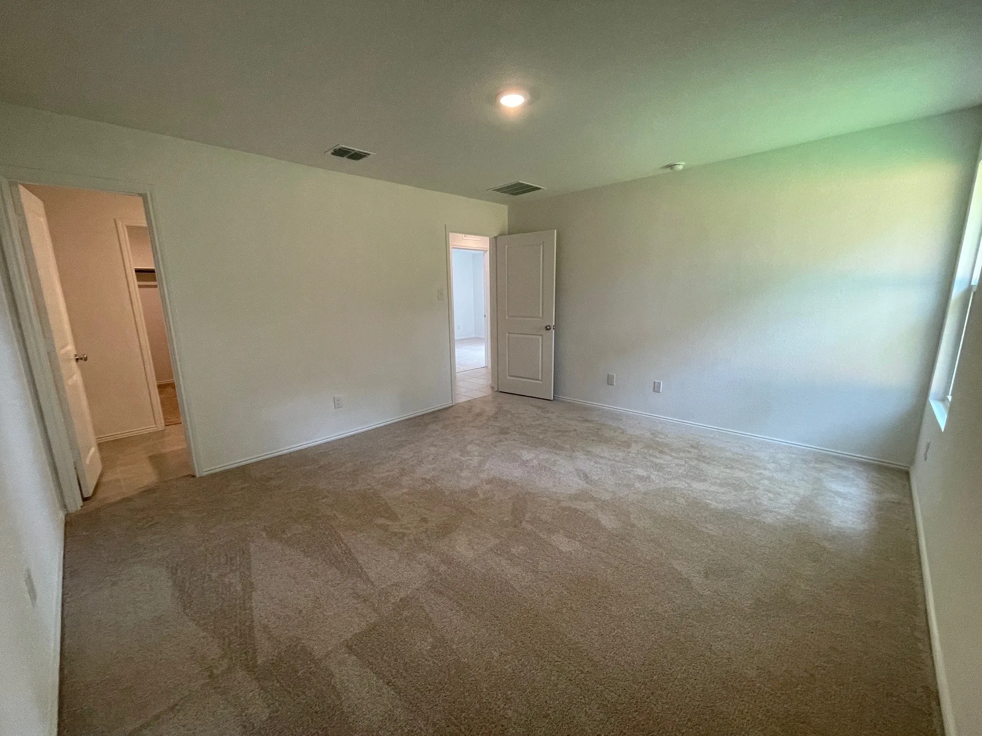 Primary bedroom showing entry door and bath.