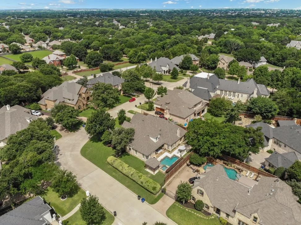 Aerial perspective highlighting a residential neighborhood with extensive mature tree coverage