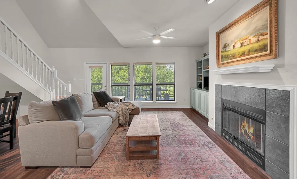 Living area with nice large windows, built in cabinetry and fireplace.