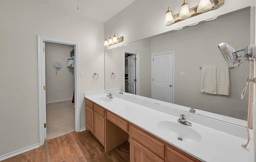Primary ensuite with double sinks with built in cabinetry and a walk-in closet.