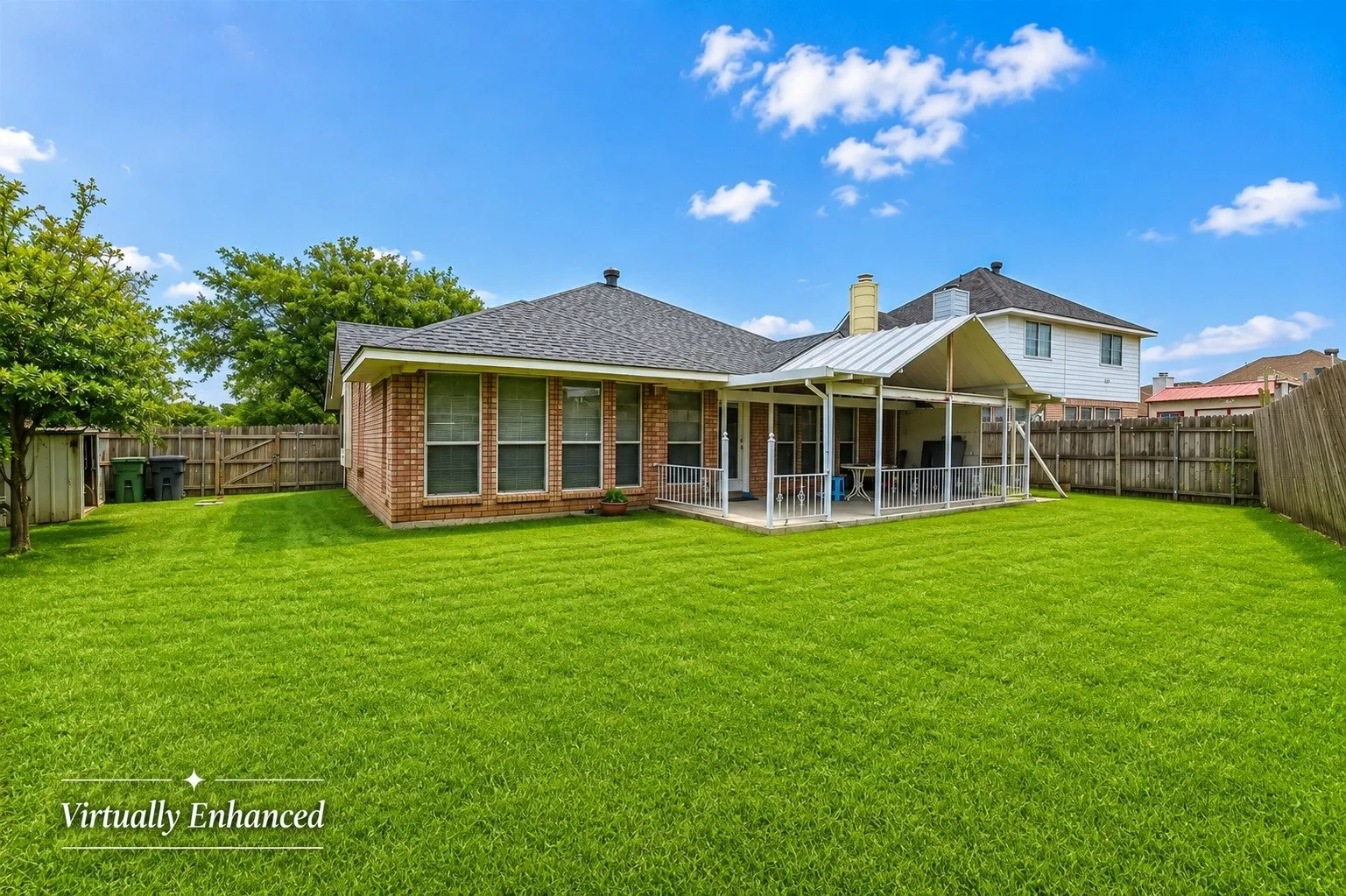 Expansive green lawn, brick exterior, multiple windows, screened patio, and privacy fencing