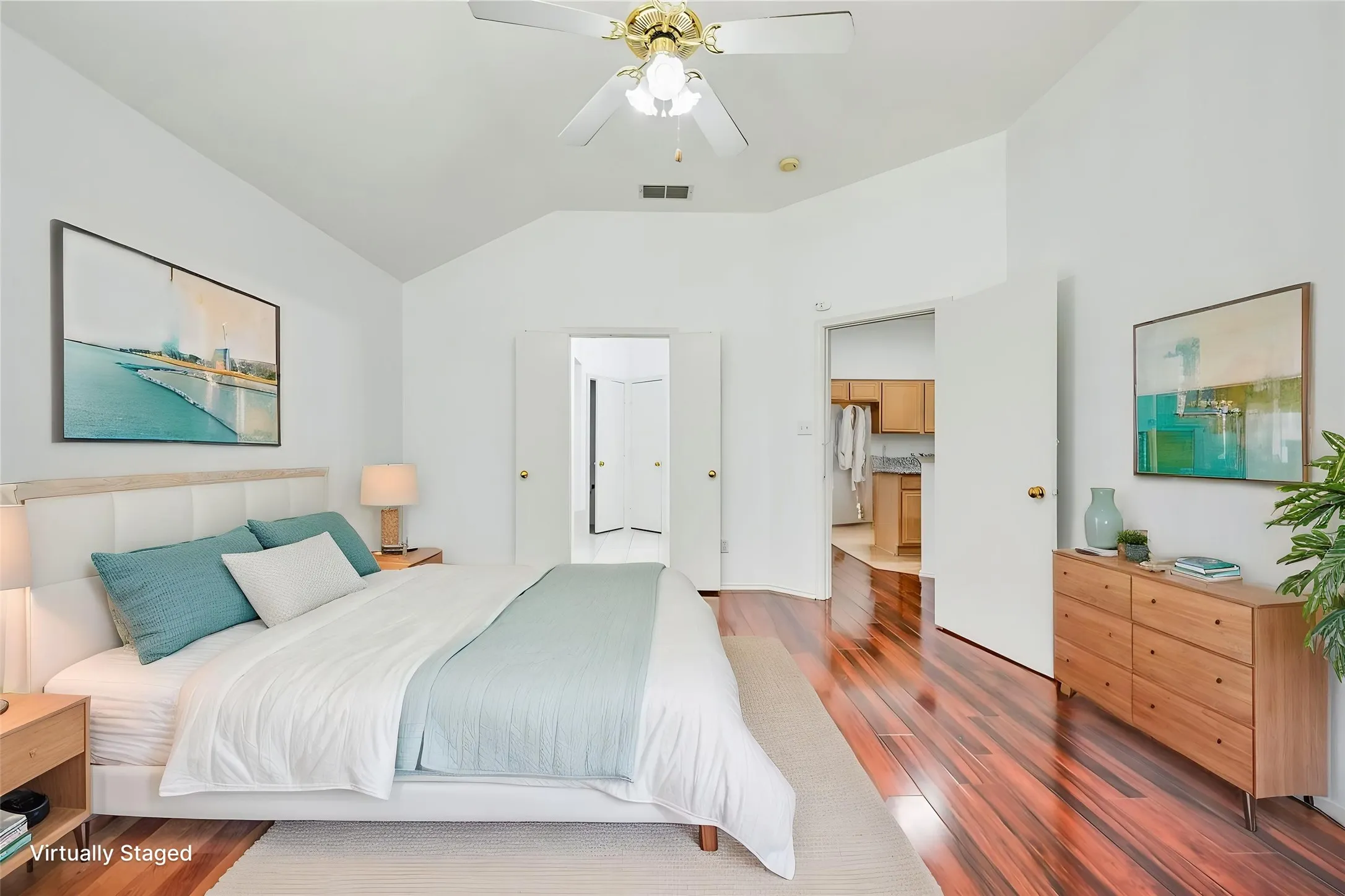 Vaulted ceiling, ceiling fan with light fixture, hardwood flooring, and white interior doors