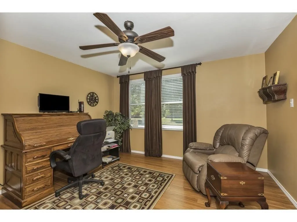 Interior room featuring wood-finish flooring and a ceiling fan with integrated lighting