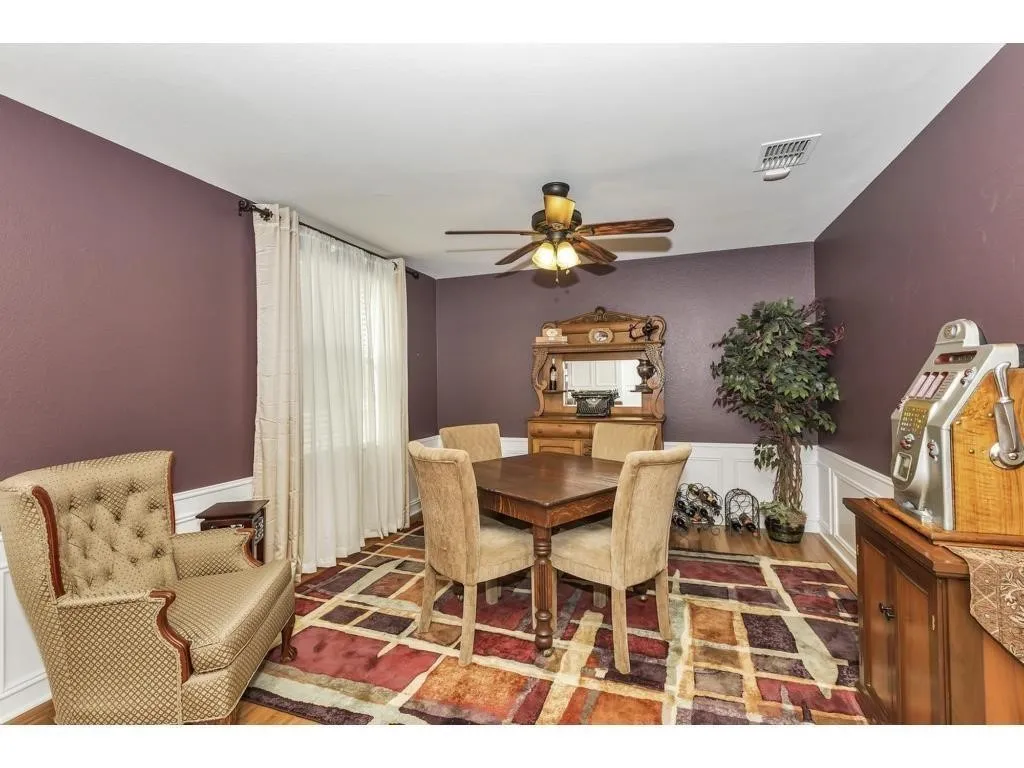 Dining area with wood-finish flooring, white crown molding, and a ceiling fan with integrated lighting