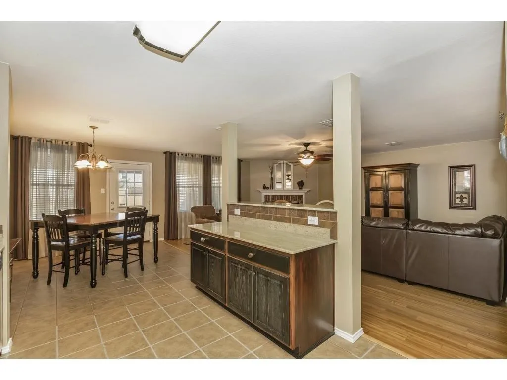 Open-concept dining area featuring tile flooring, a multi-light chandelier, and a white paneled door with glass inserts
